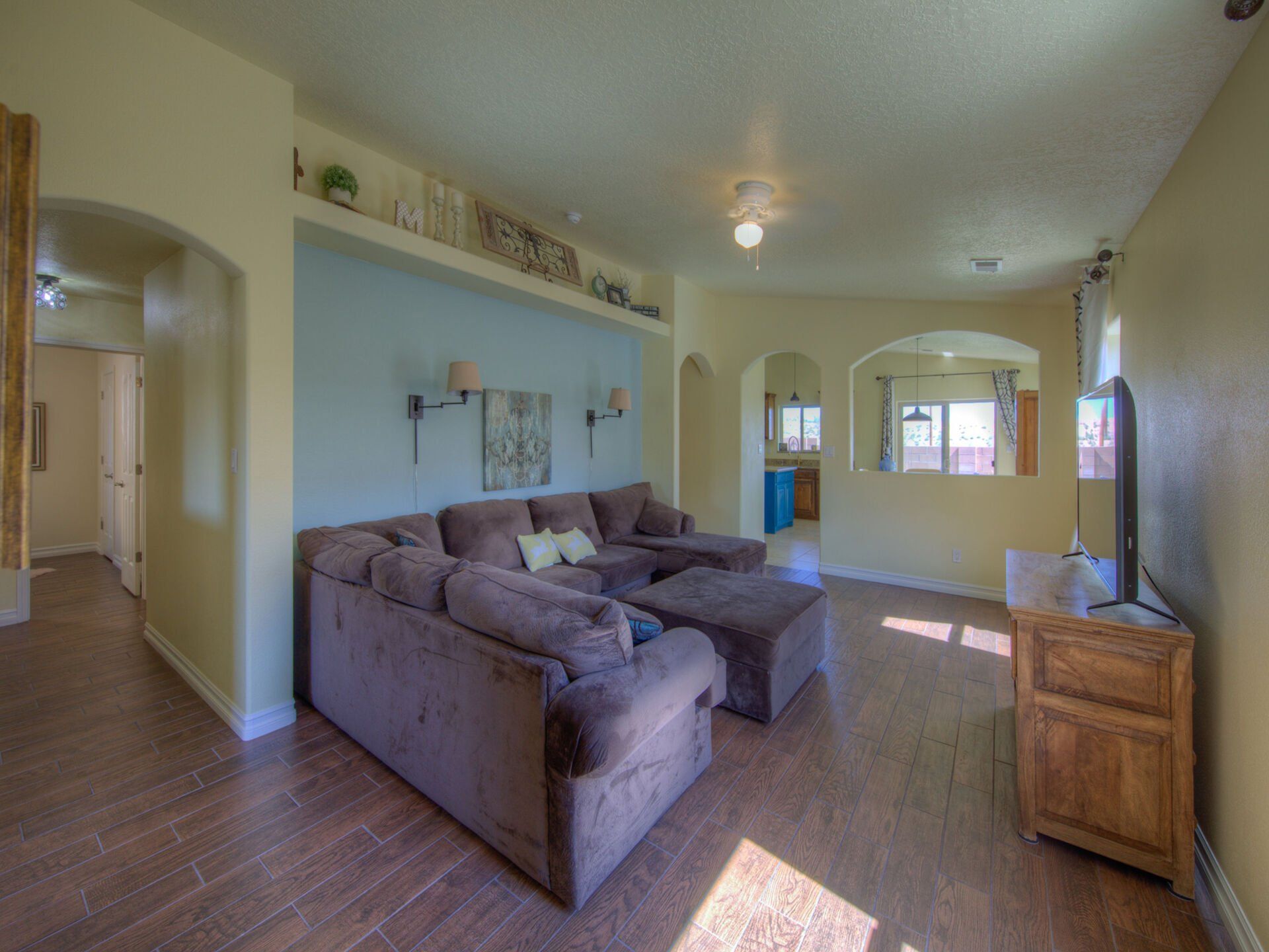 A living room with a large sectional couch and a flat screen tv.