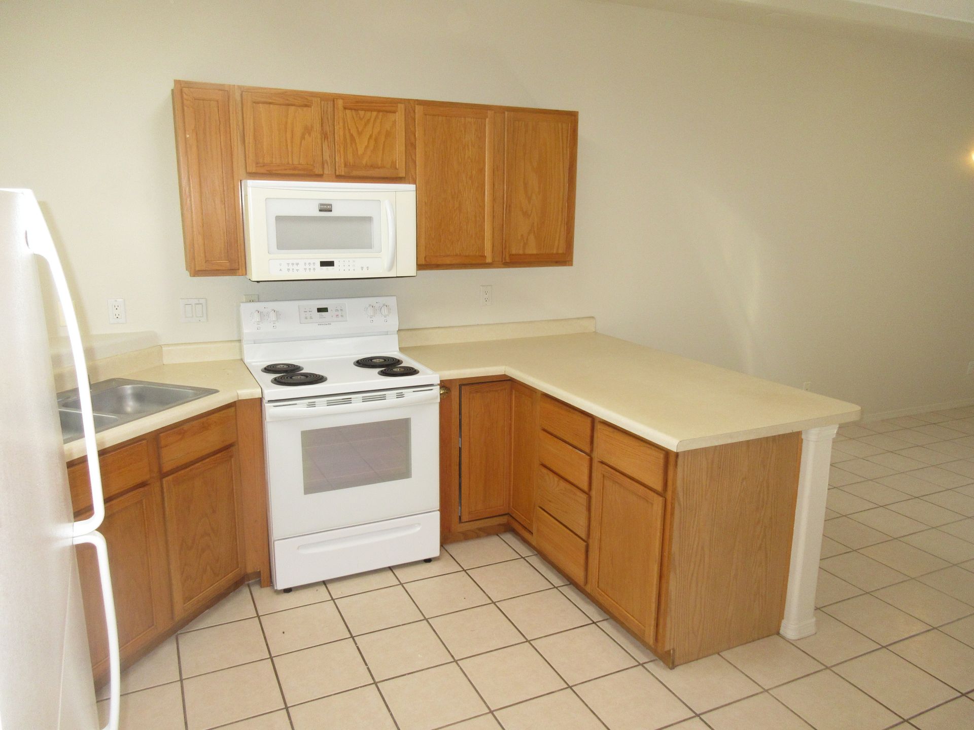 A kitchen with wooden cabinets and a white stove