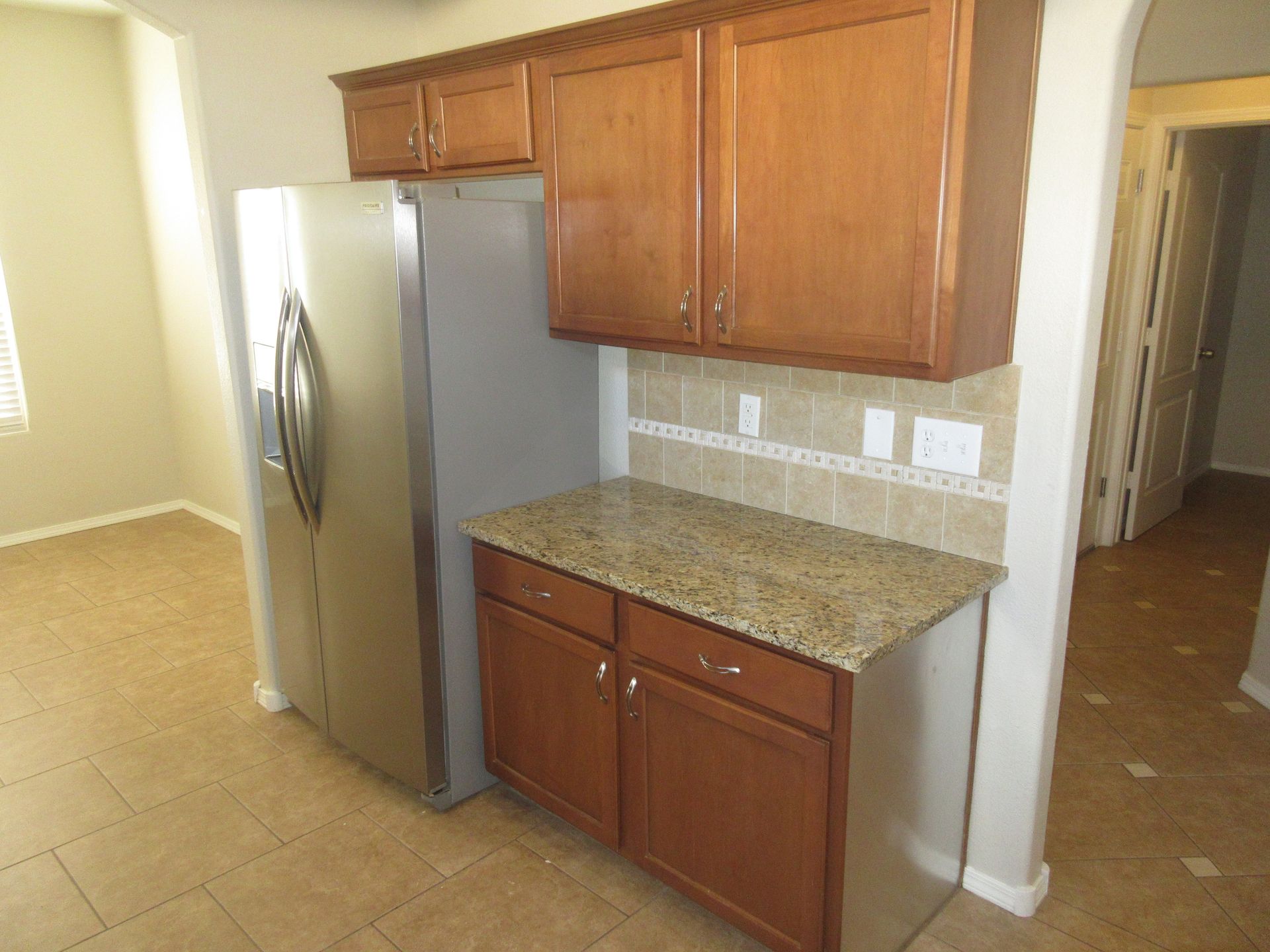 A kitchen with stainless steel appliances , granite counter tops , and wooden cabinets.