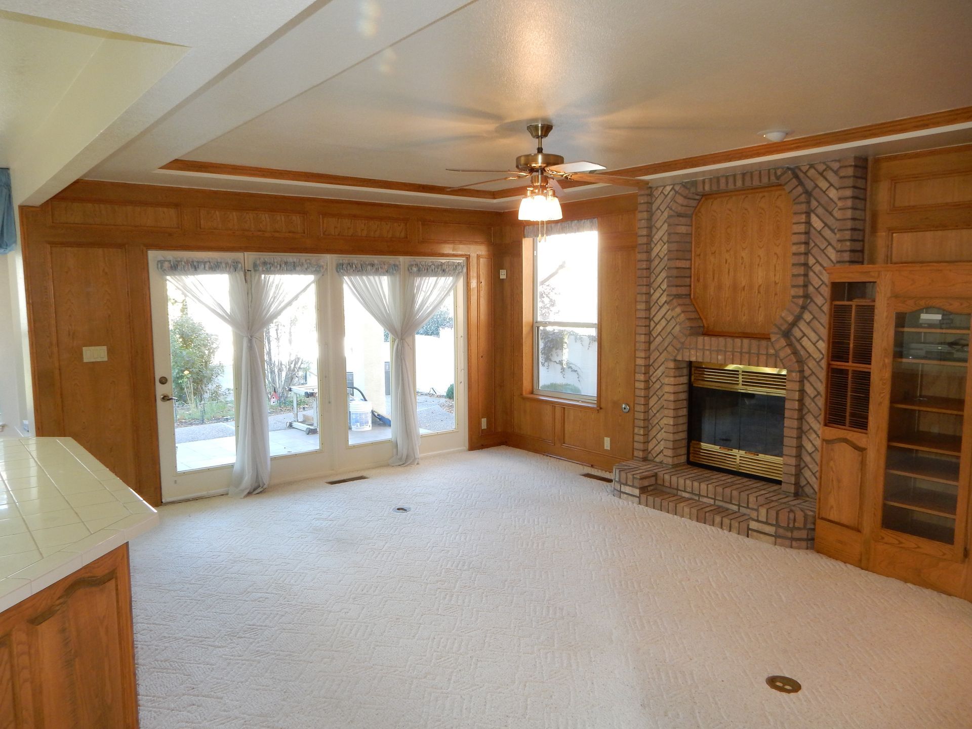 An empty living room with a fireplace and sliding glass doors