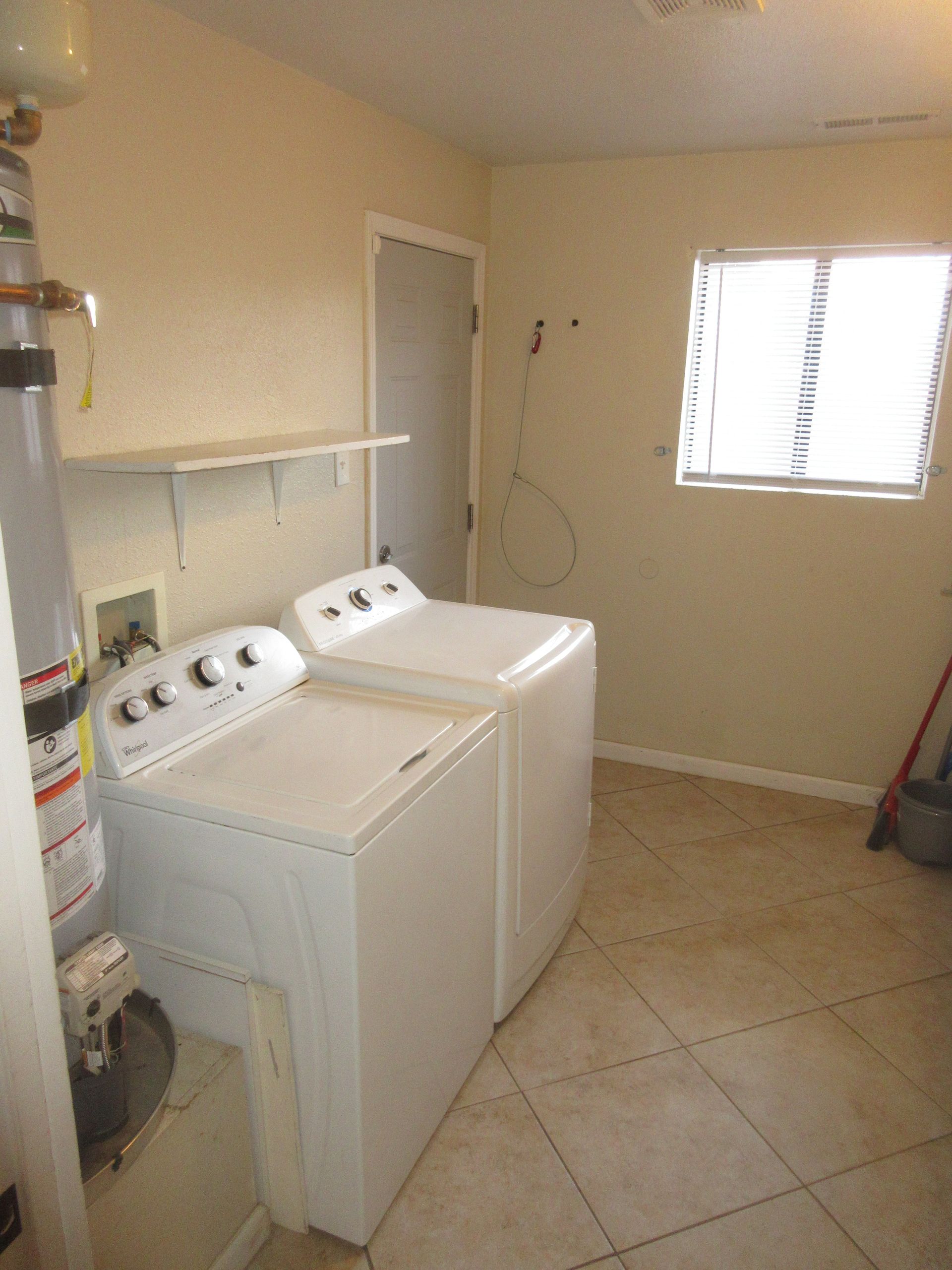 A laundry room with a washer and dryer and a window