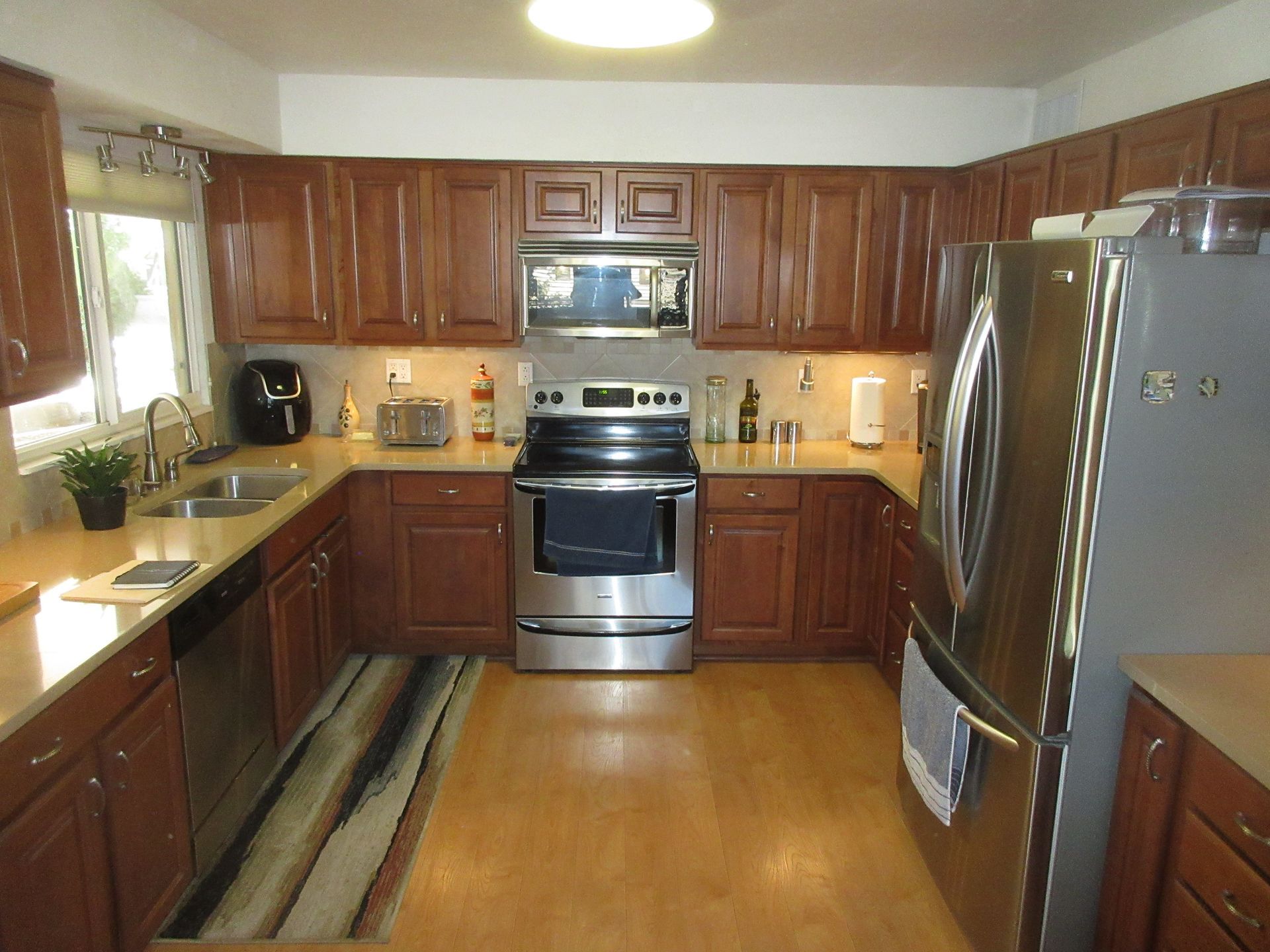 A kitchen with stainless steel appliances and wooden cabinets