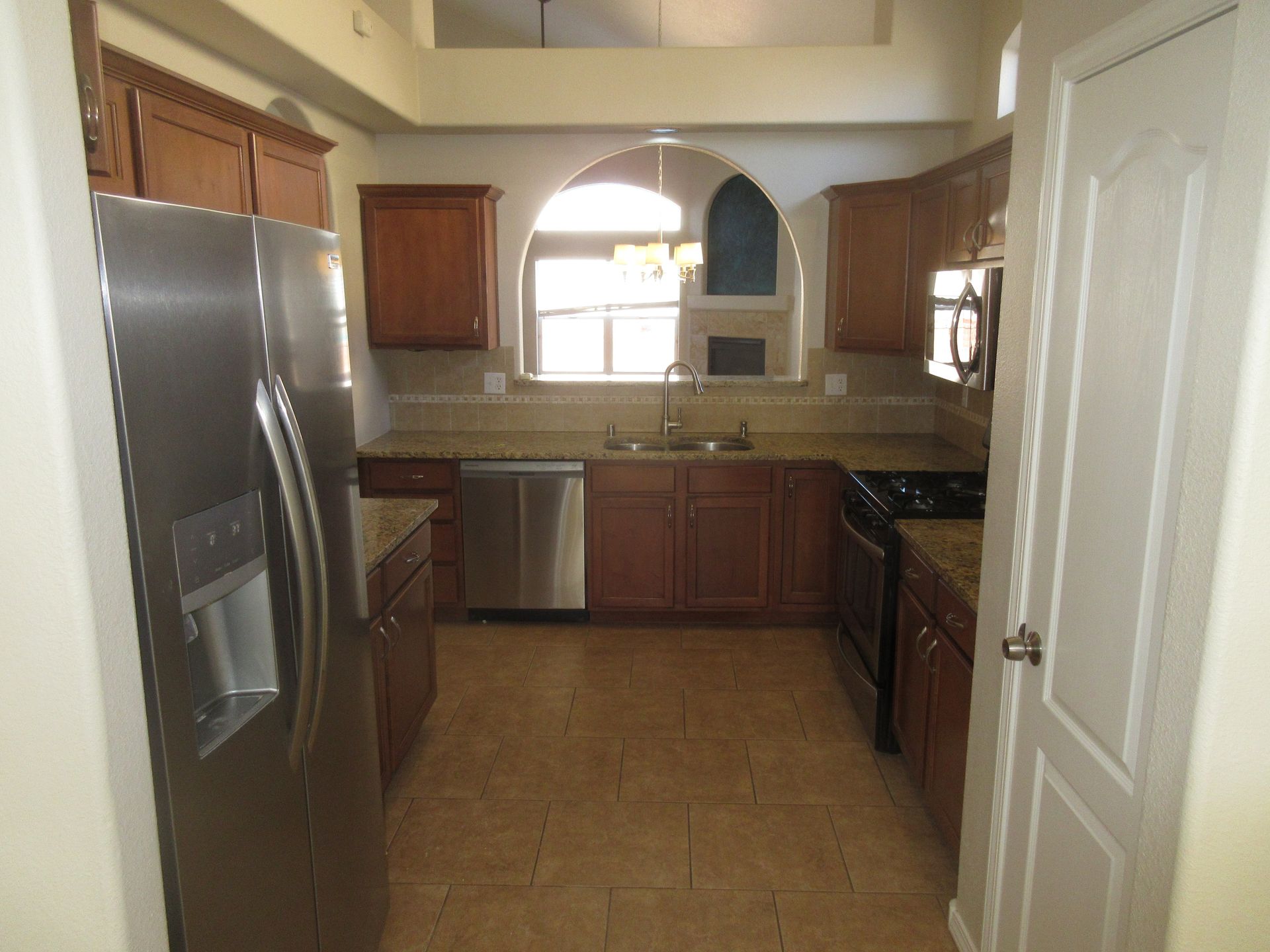 A kitchen with stainless steel appliances and wooden cabinets