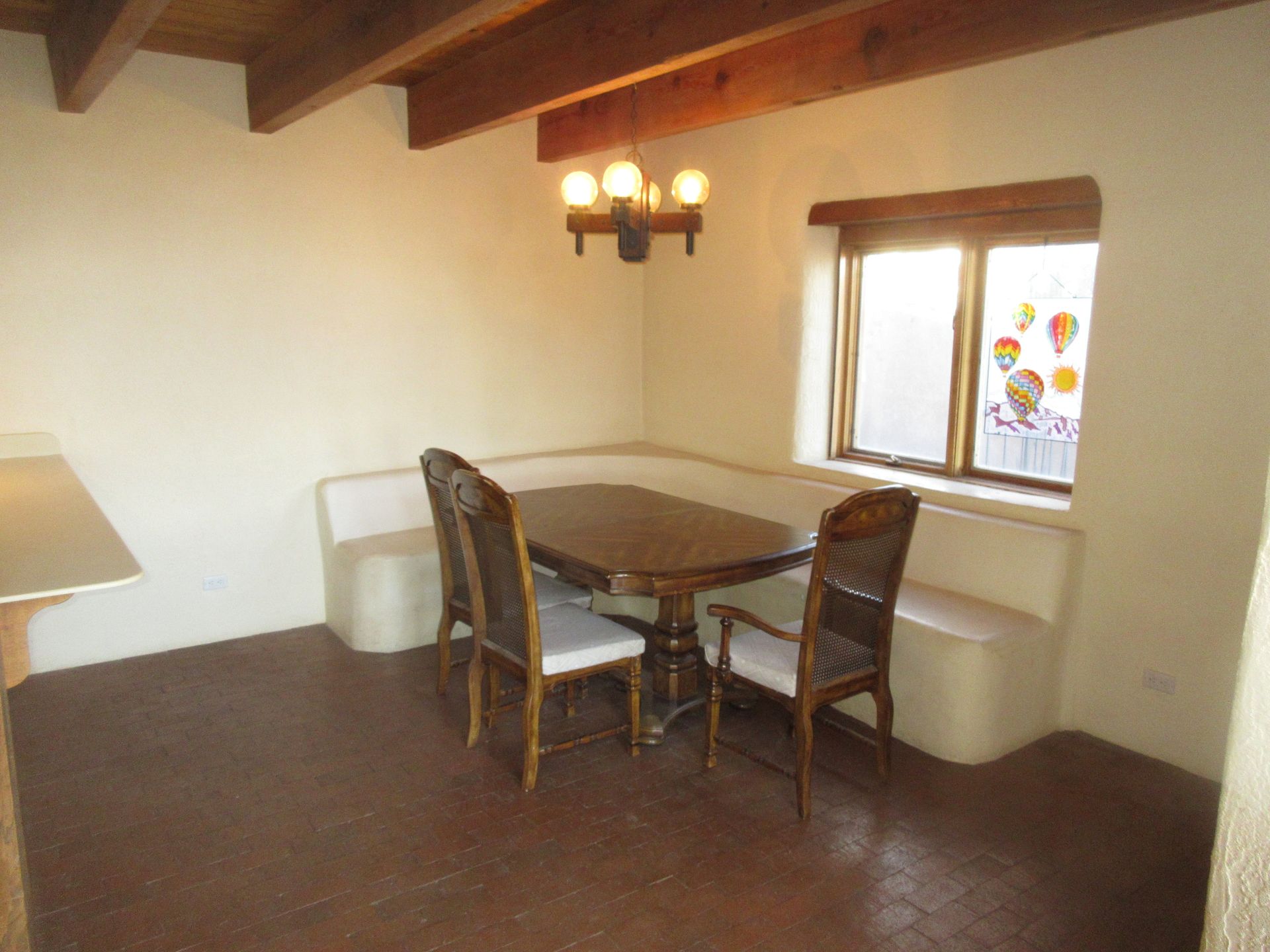 A dining room with a table and chairs and a window