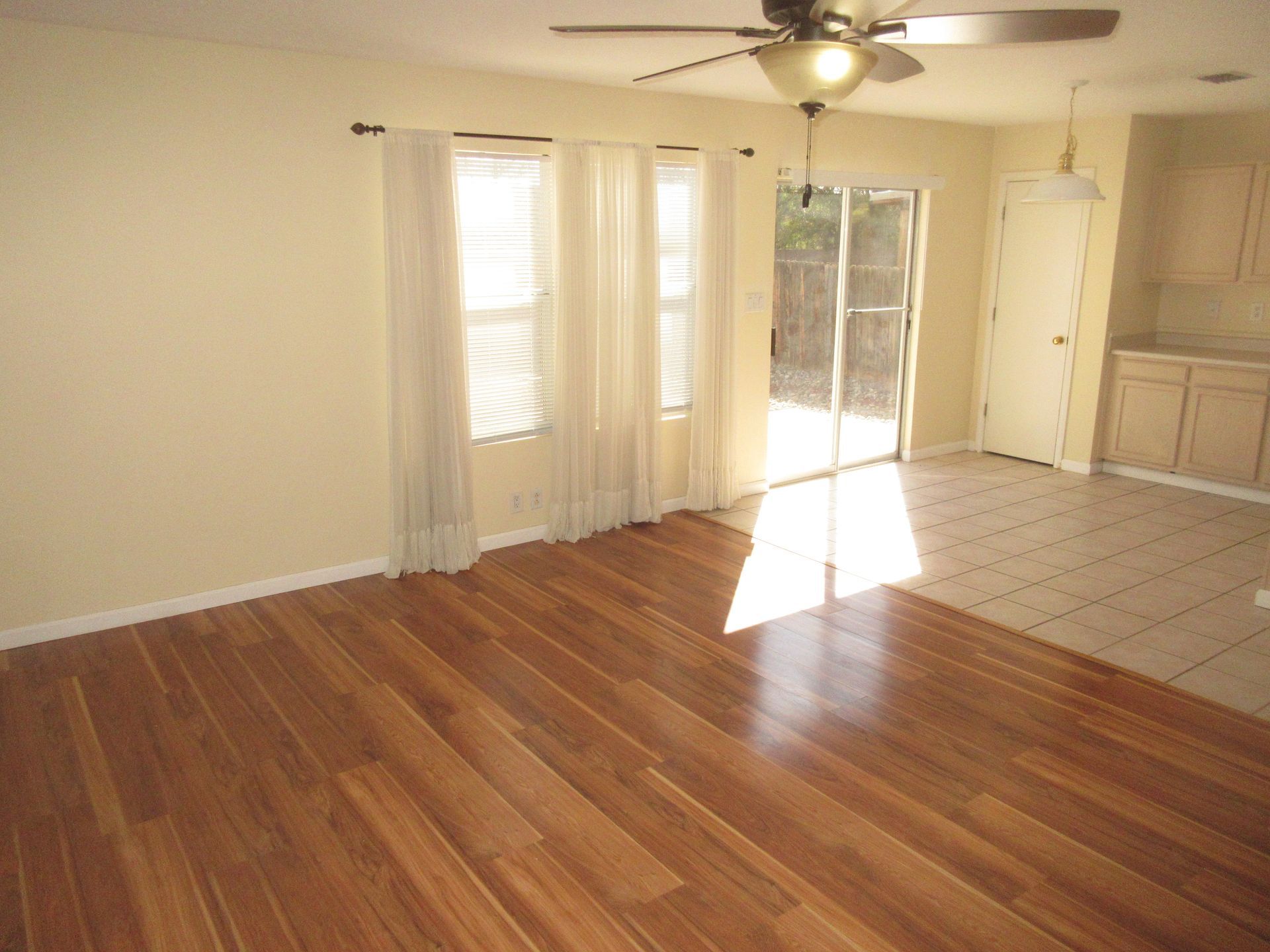 A living room with hardwood floors and a ceiling fan