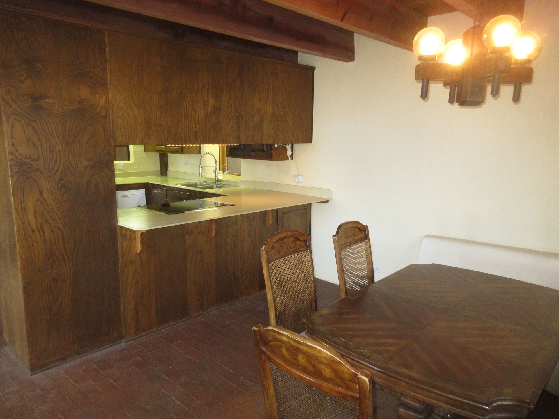 A kitchen with a table and chairs and a chandelier