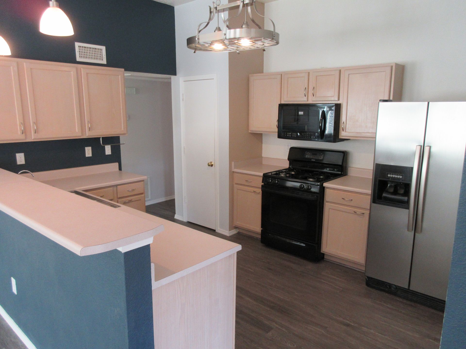 A kitchen with stainless steel appliances and wooden cabinets
