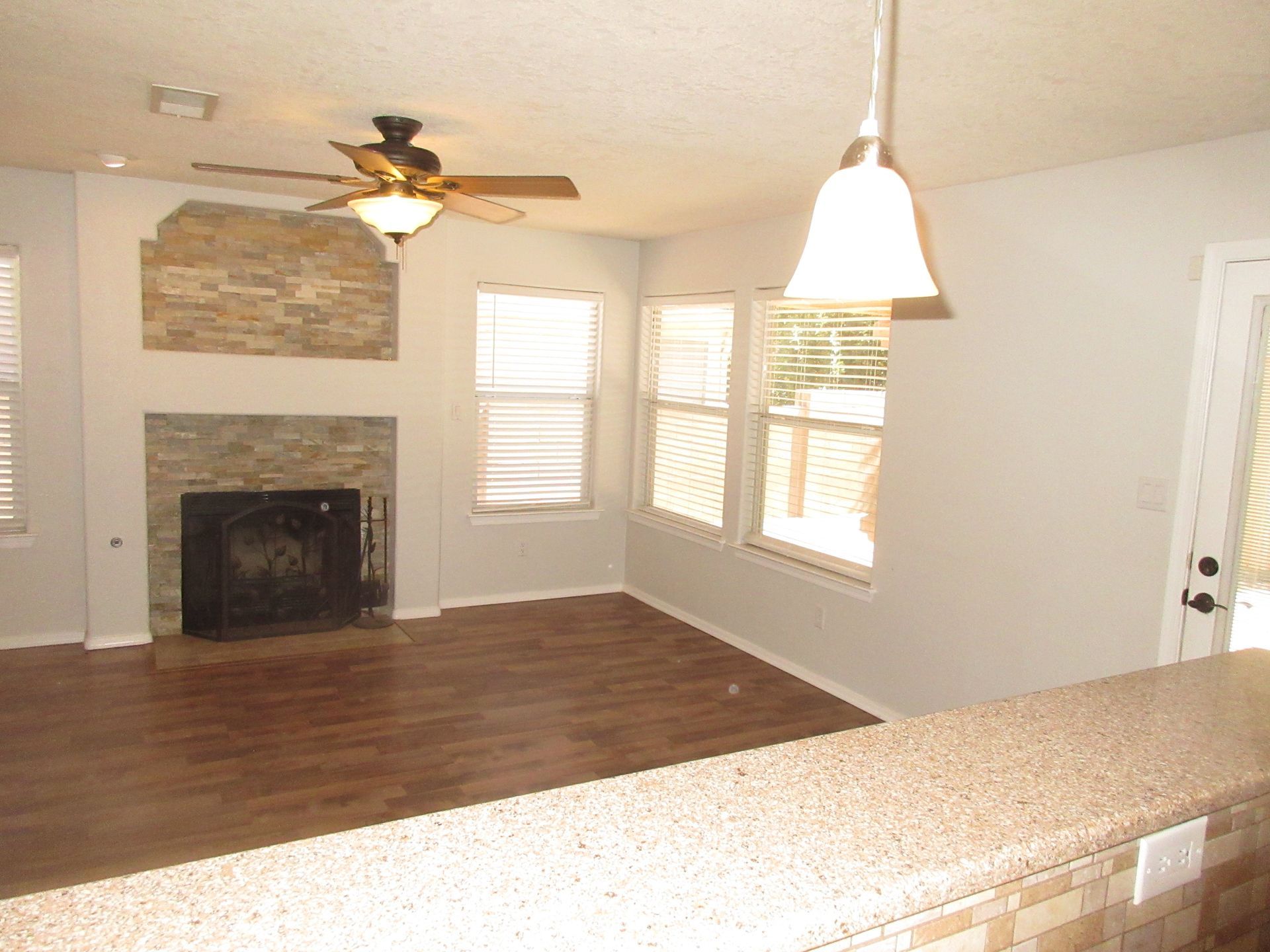 A living room with a fireplace and a ceiling fan