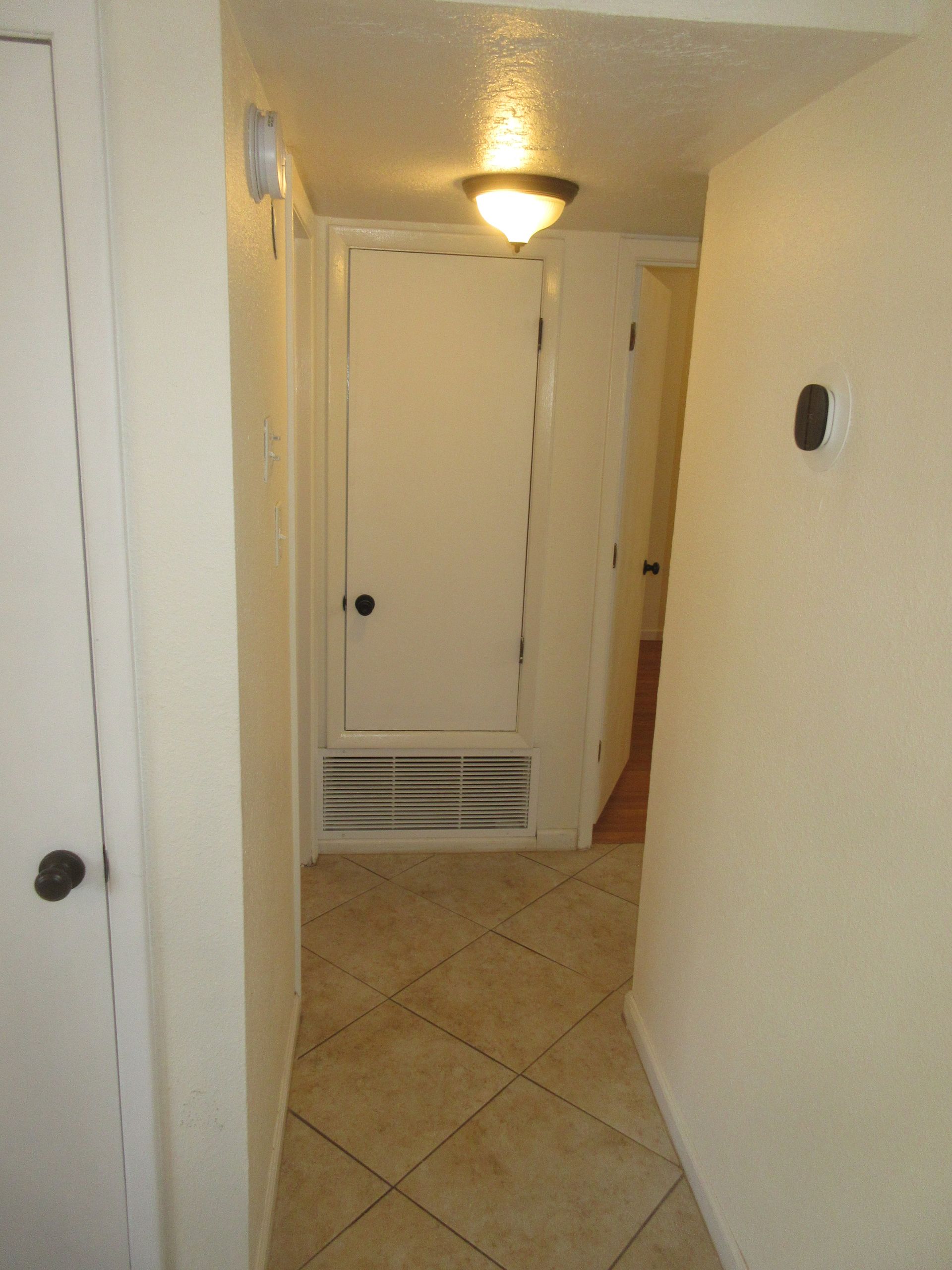 A hallway with tile floors and white walls
