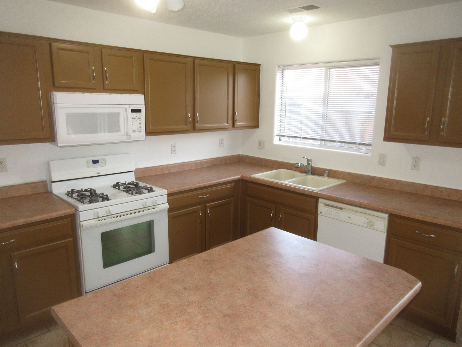 A kitchen with brown cabinets and a white stove top oven