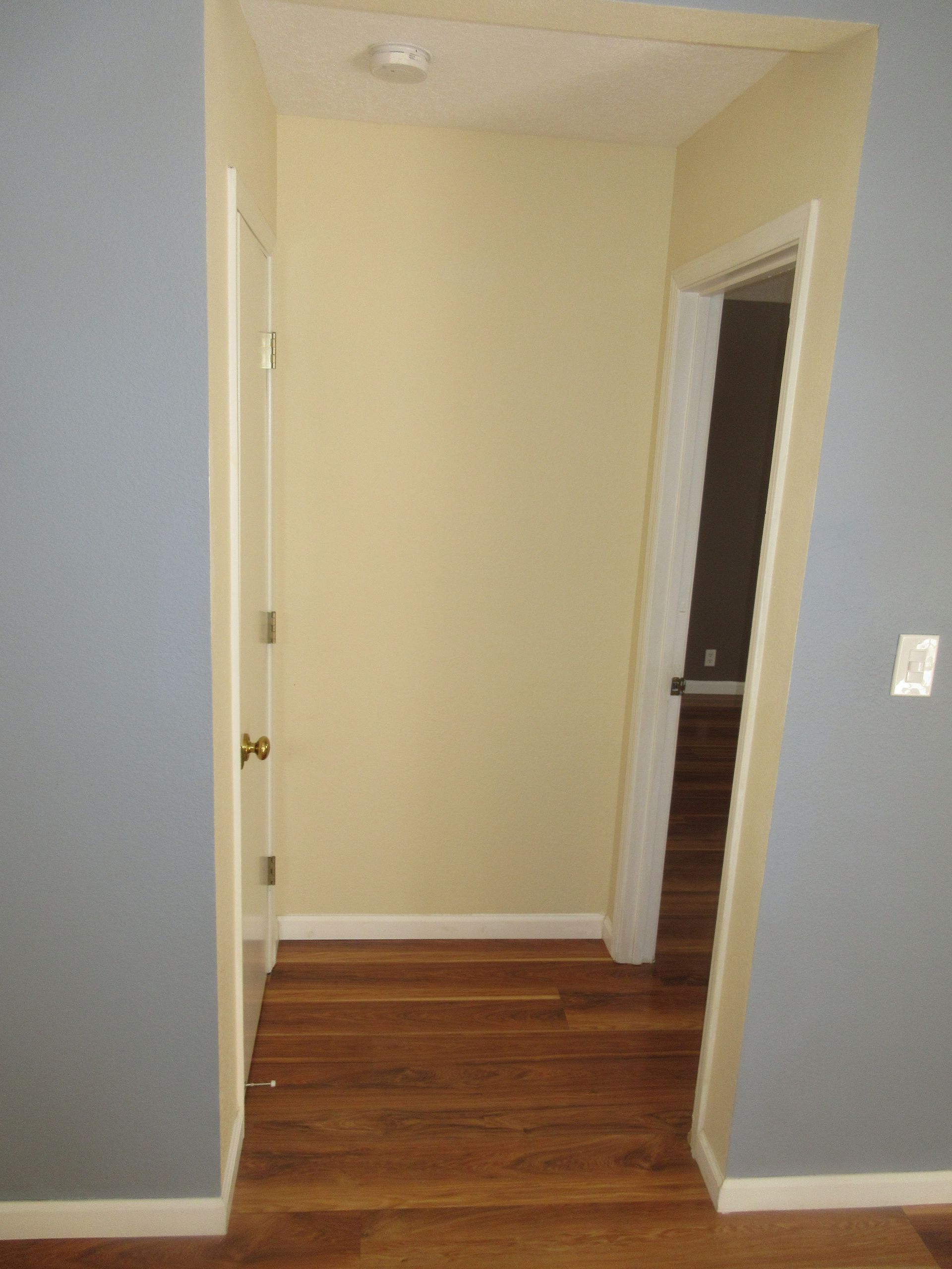 A hallway with hardwood floors and blue walls