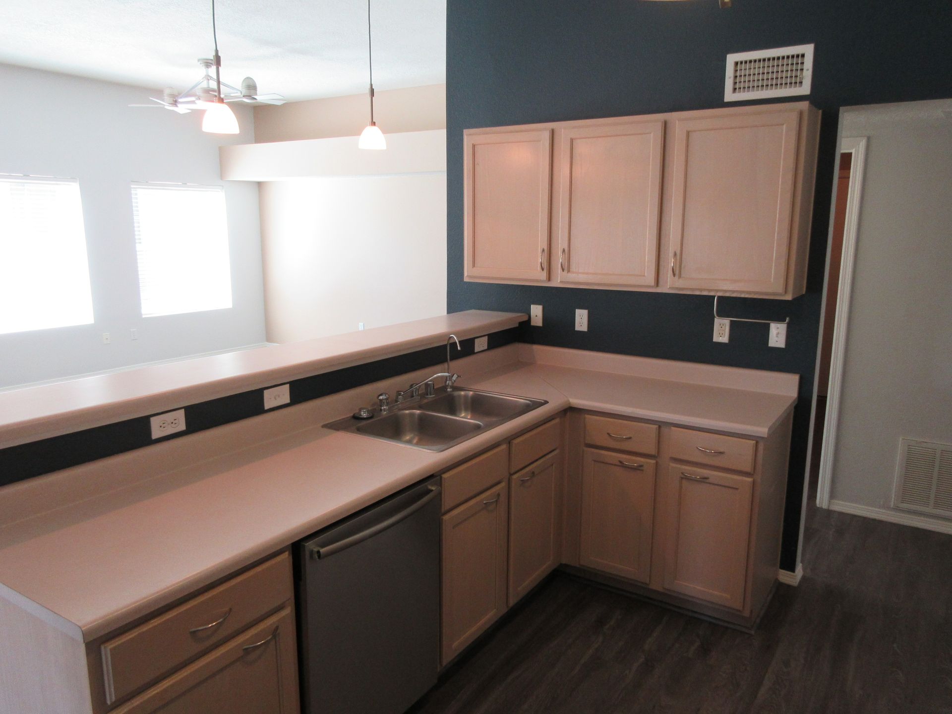 An empty kitchen with a sink and a dishwasher
