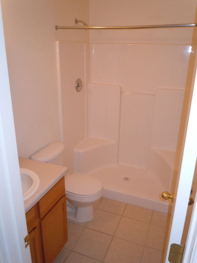 A bathroom with a toilet a sink and a shower