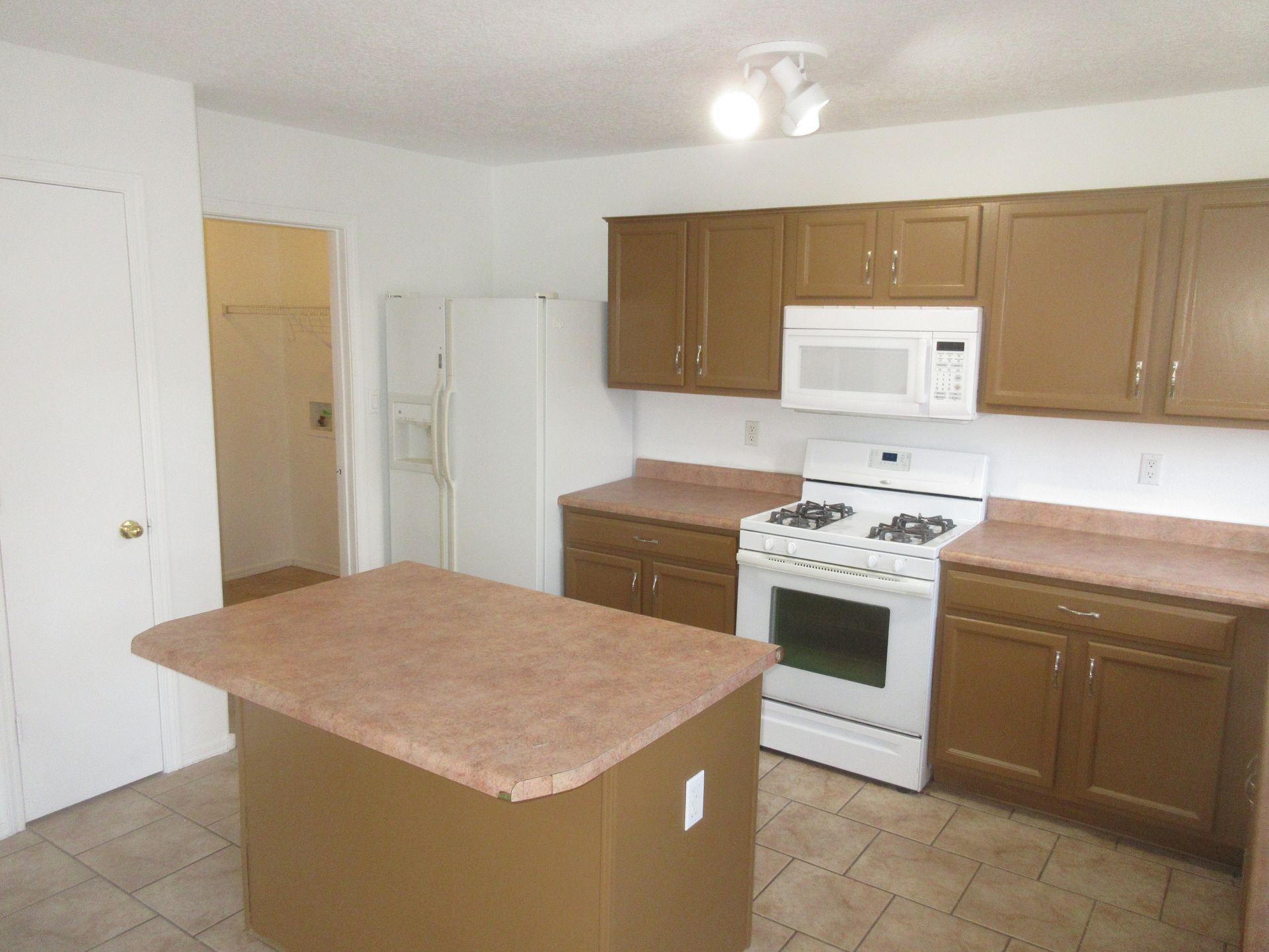 A kitchen with brown cabinets and a white stove