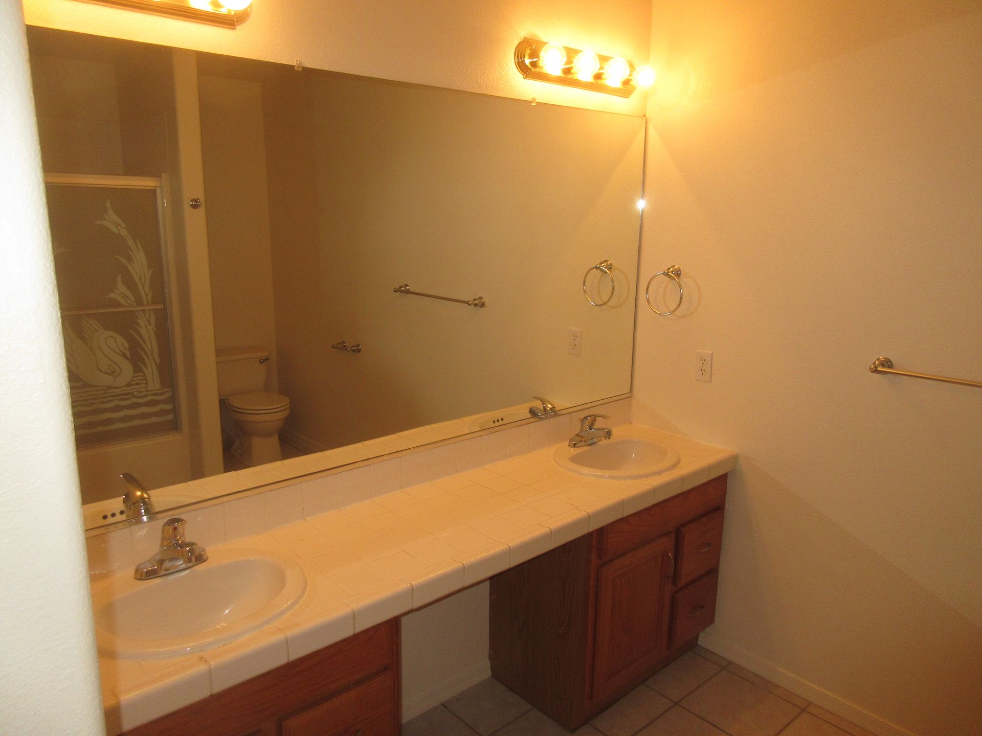 A bathroom with two sinks and a large mirror