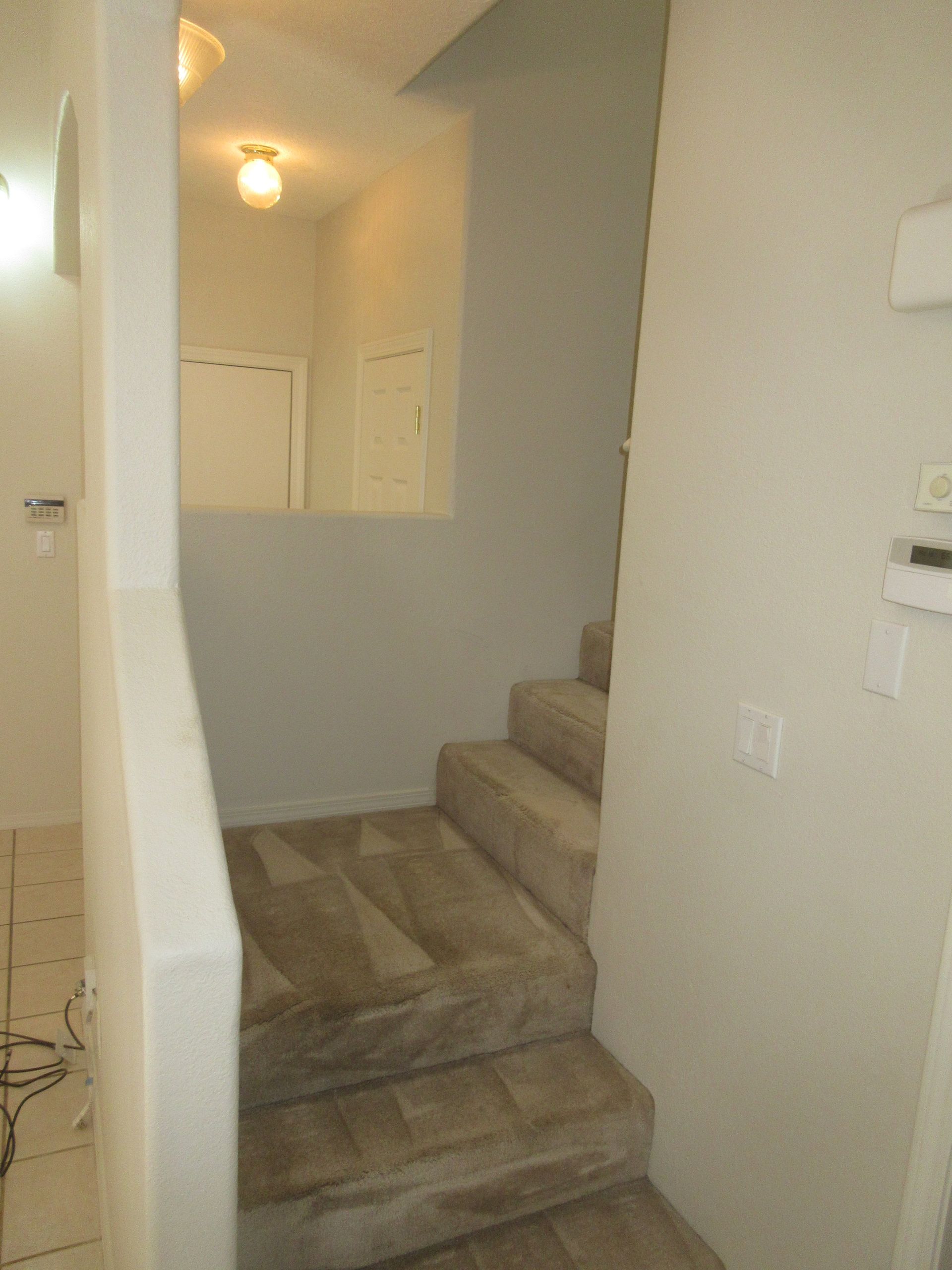A hallway with stairs leading up to the second floor of a house.