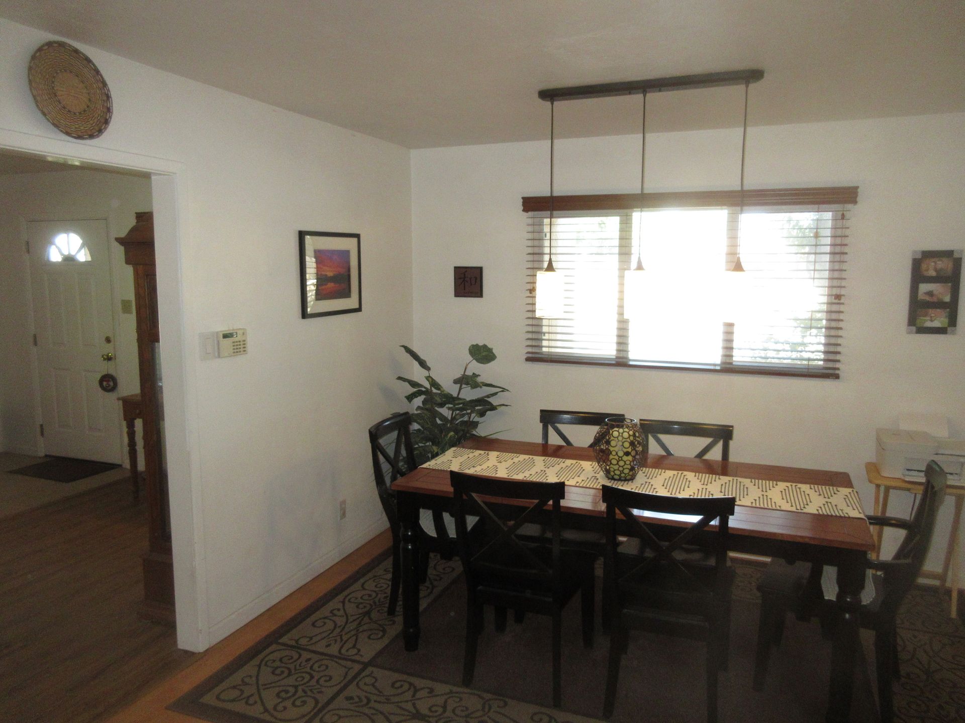 A dining room with a table and chairs and a window