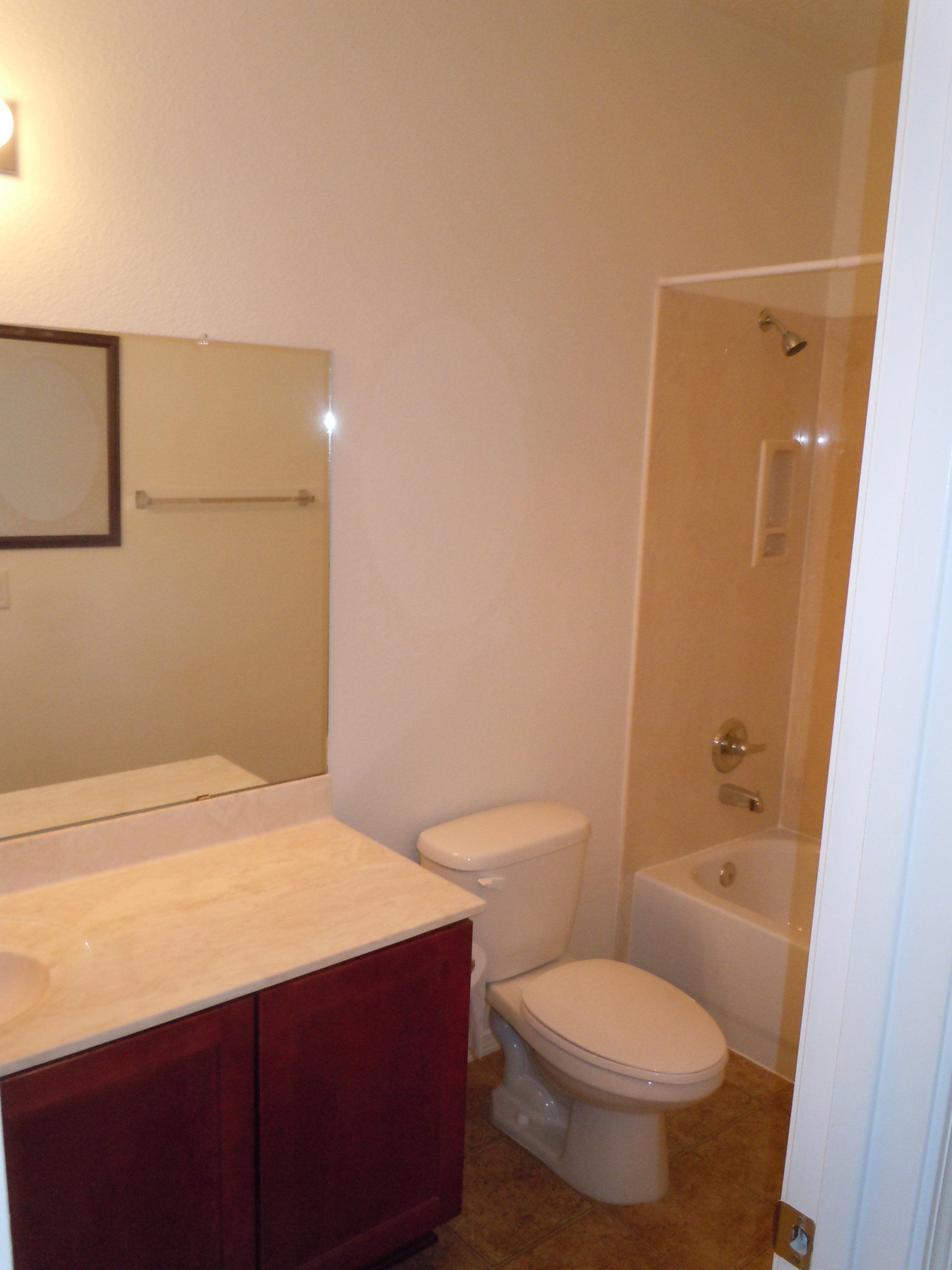 A bathroom with a toilet a sink and a mirror