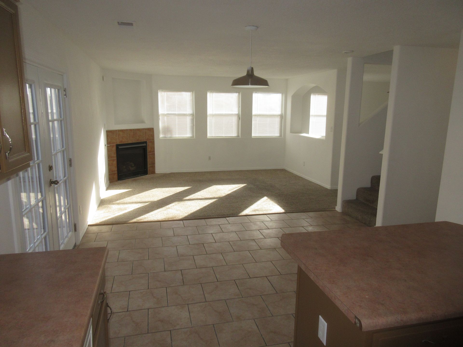An empty living room with a fireplace and stairs