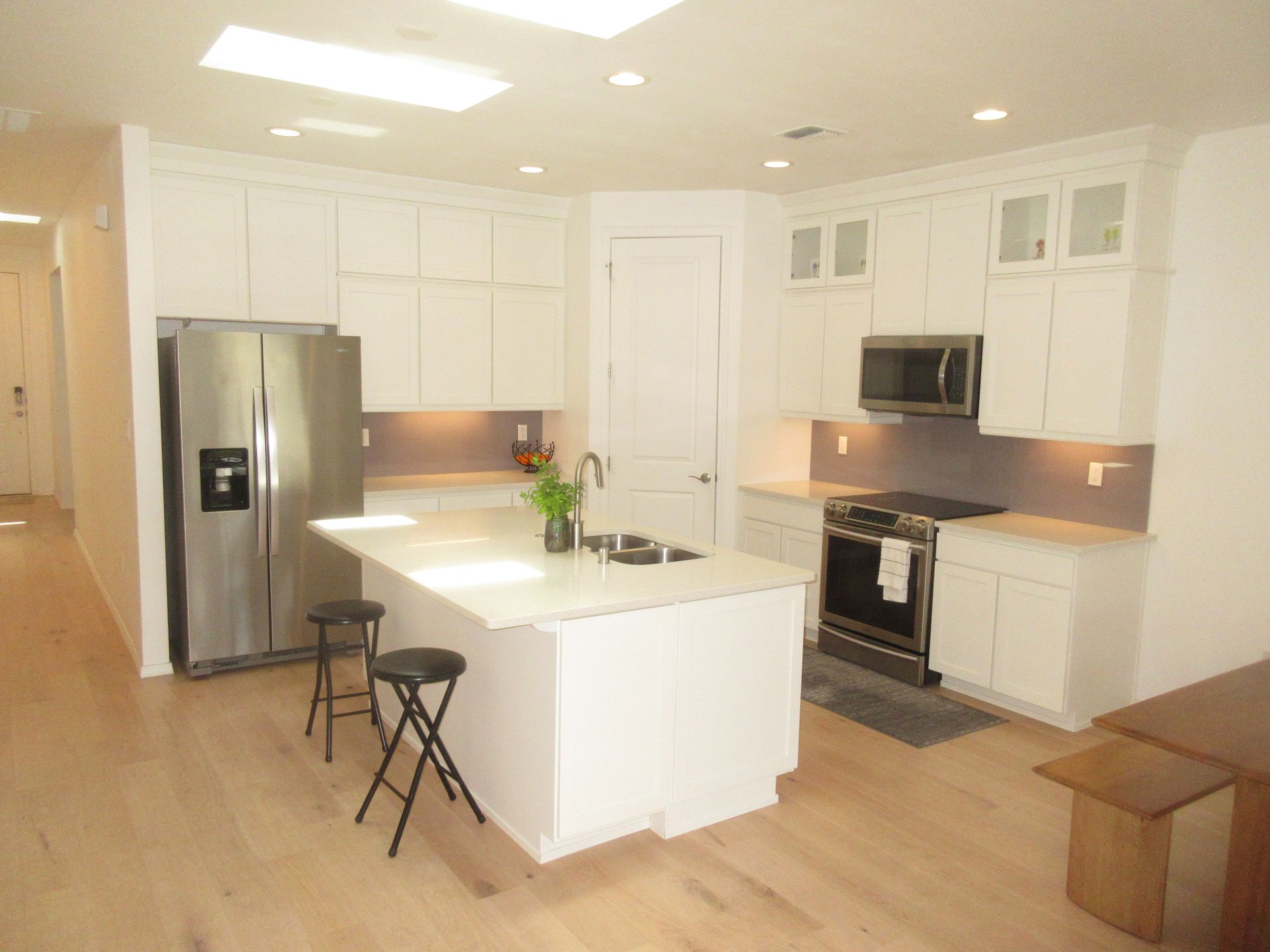 A kitchen with white cabinets and stainless steel appliances
