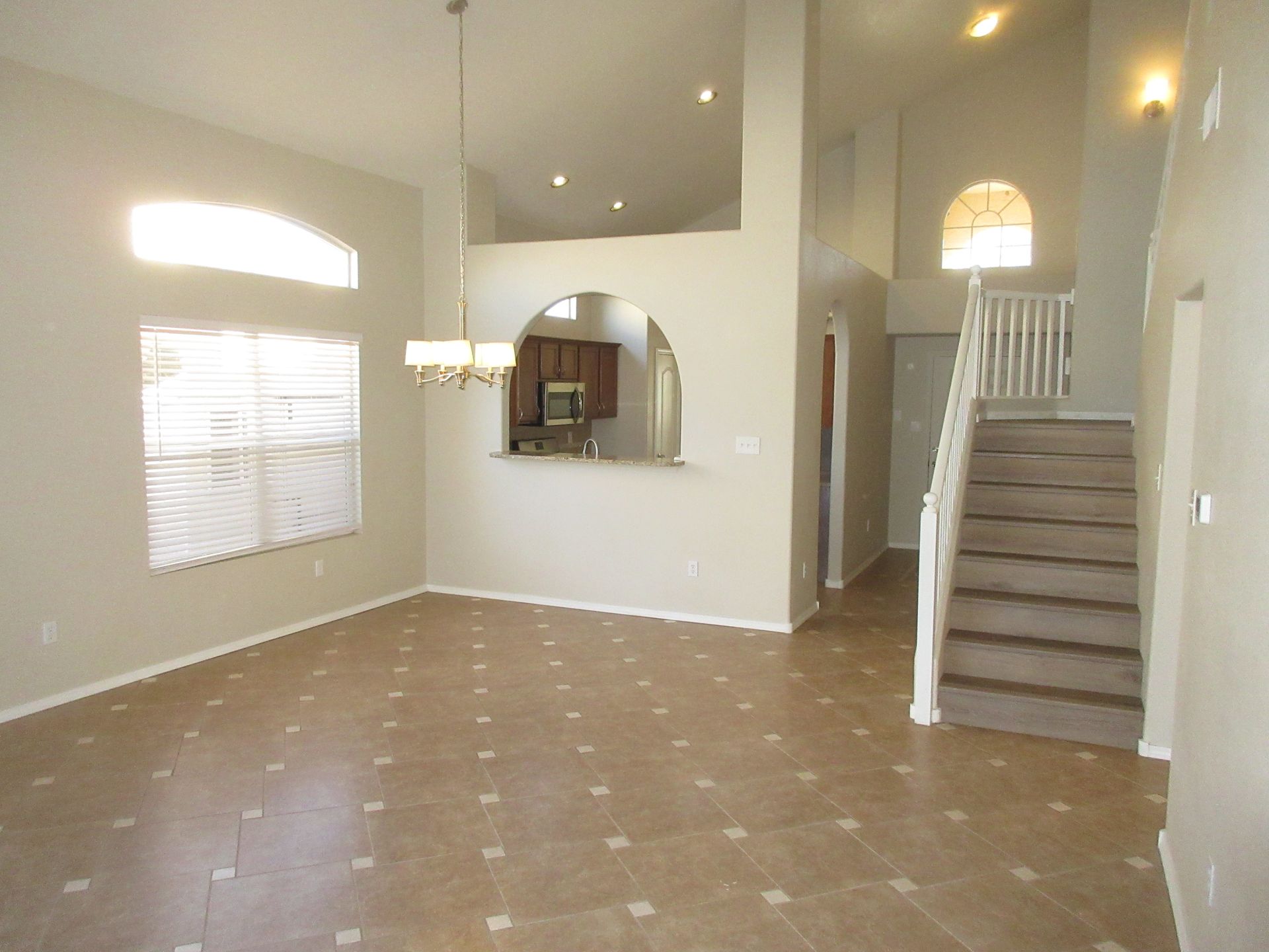 An empty living room with stairs leading up to the second floor