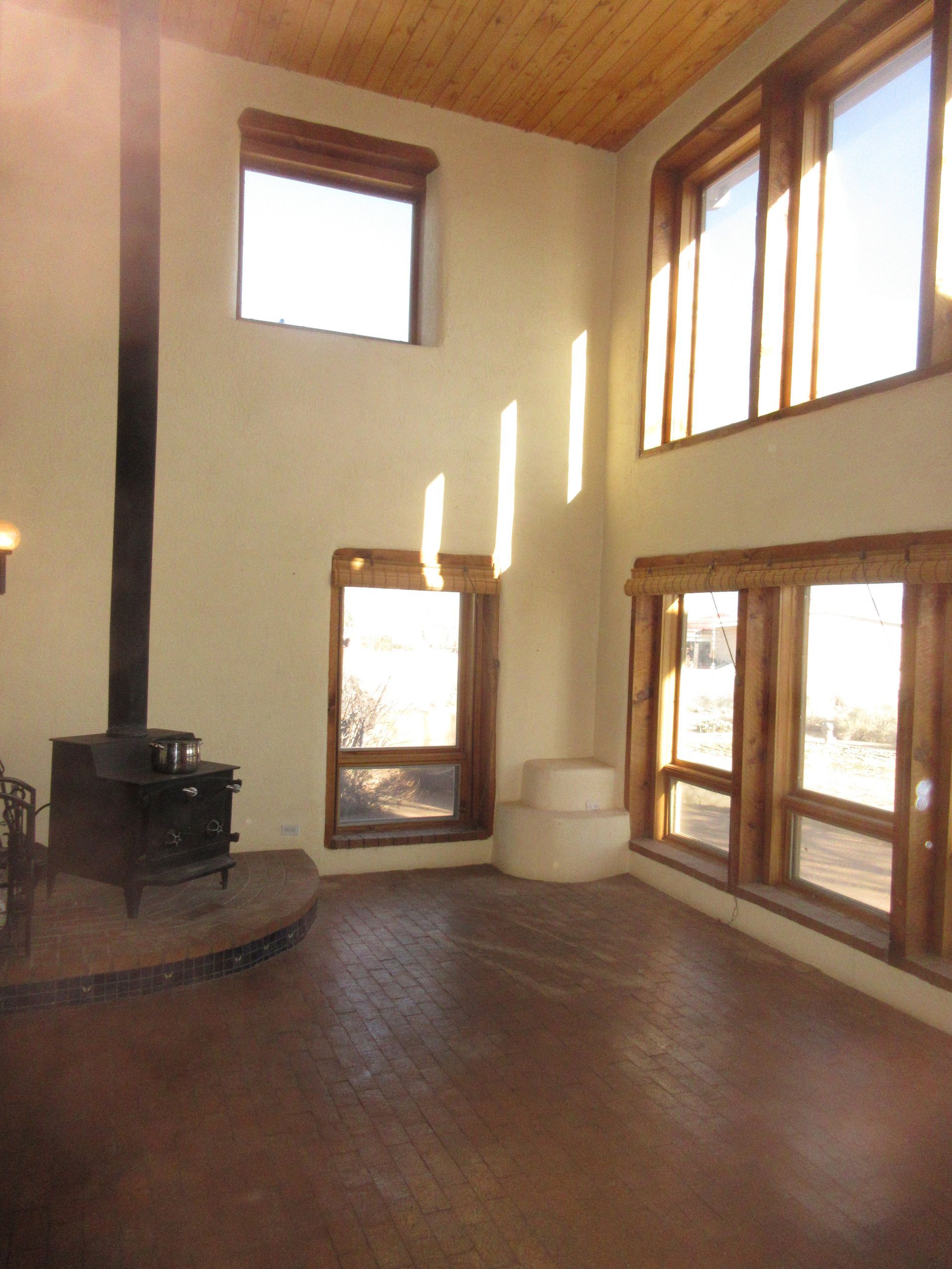 A large room with lots of windows and a wood stove