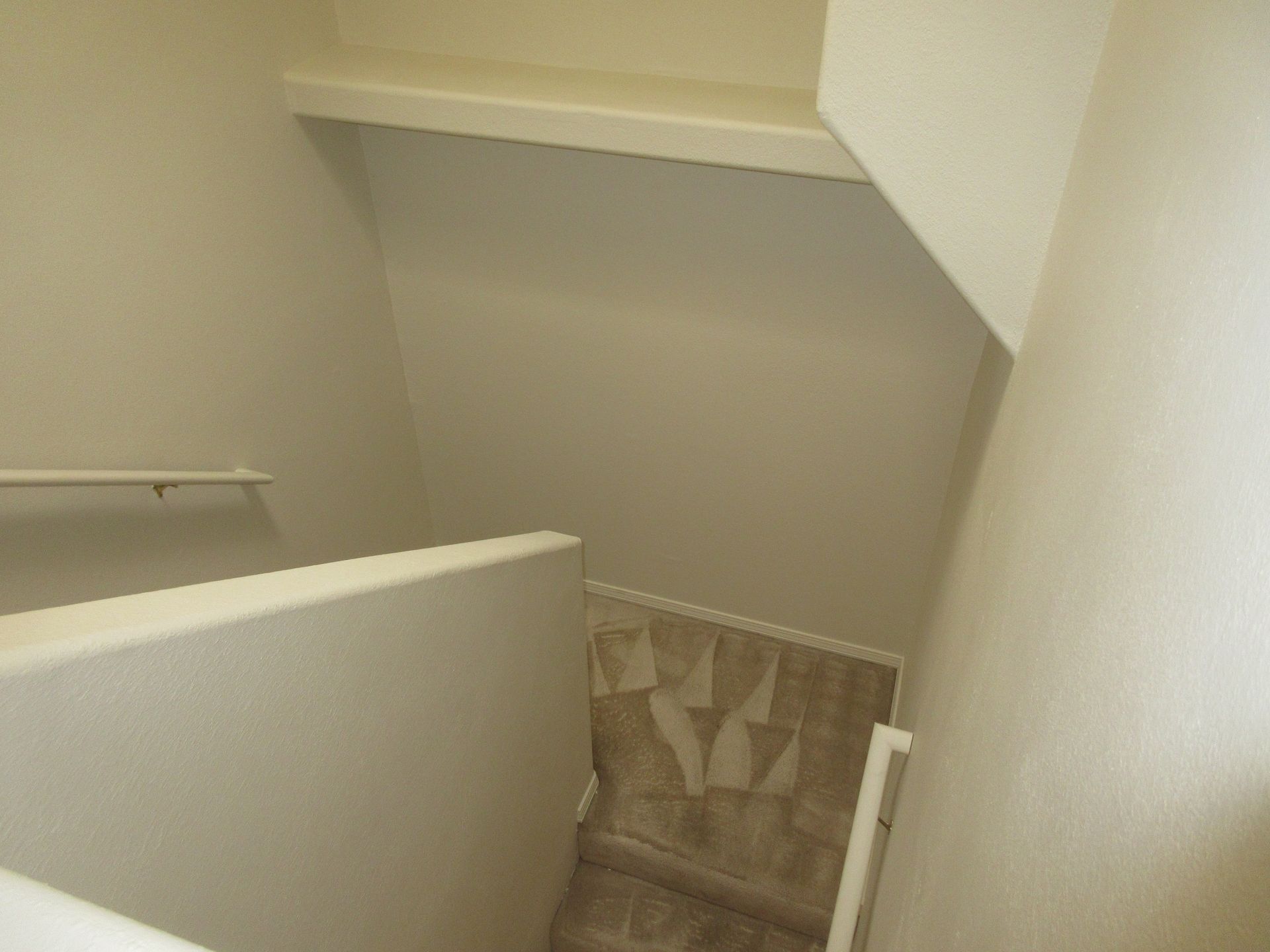 A staircase in a house with a white railing