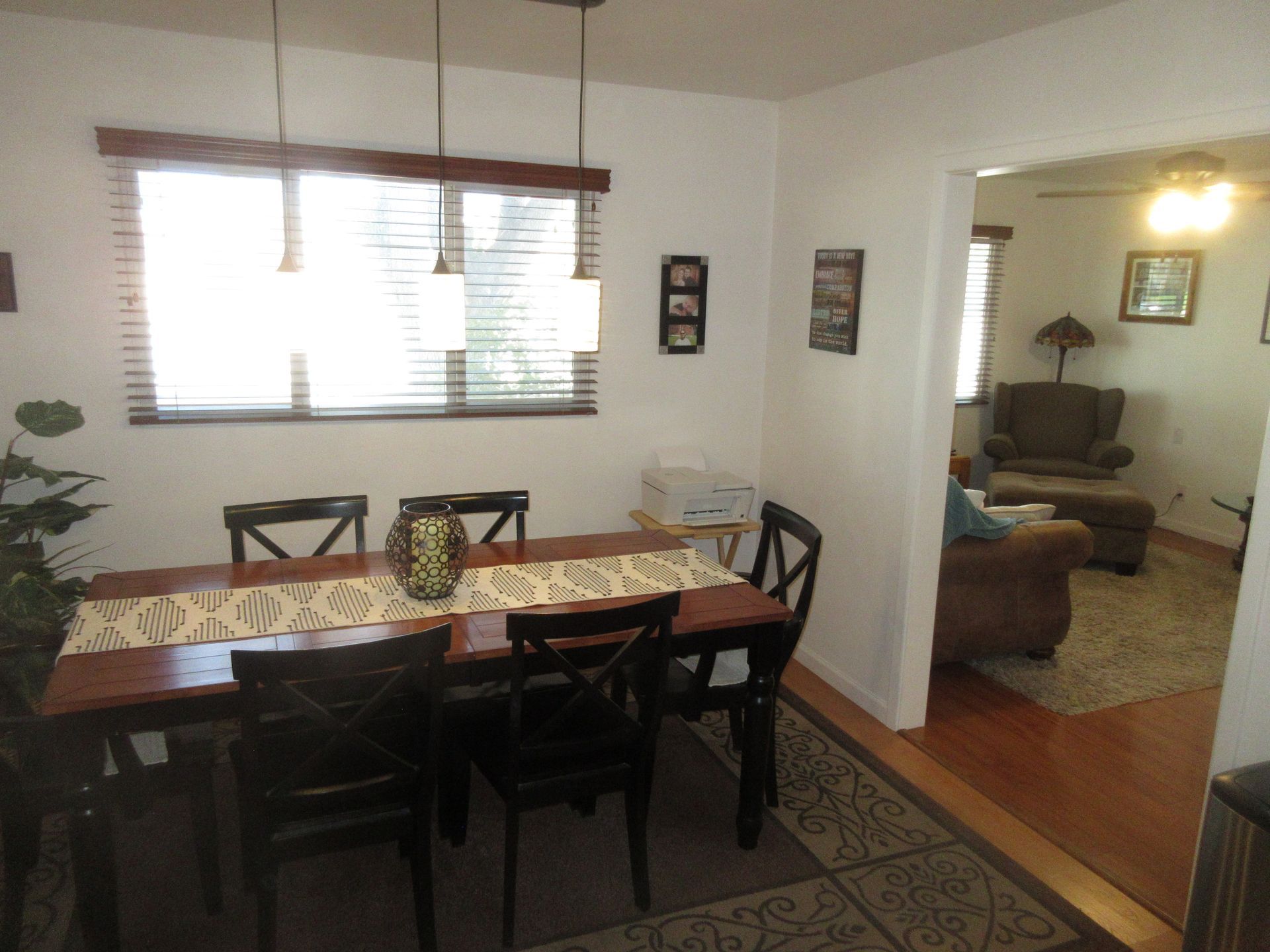 A dining room with a table and chairs and a window