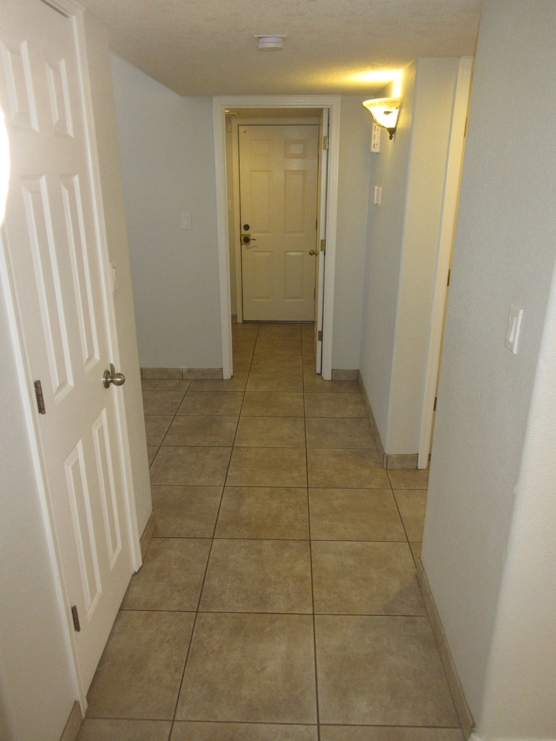 A hallway with tile floors and white doors