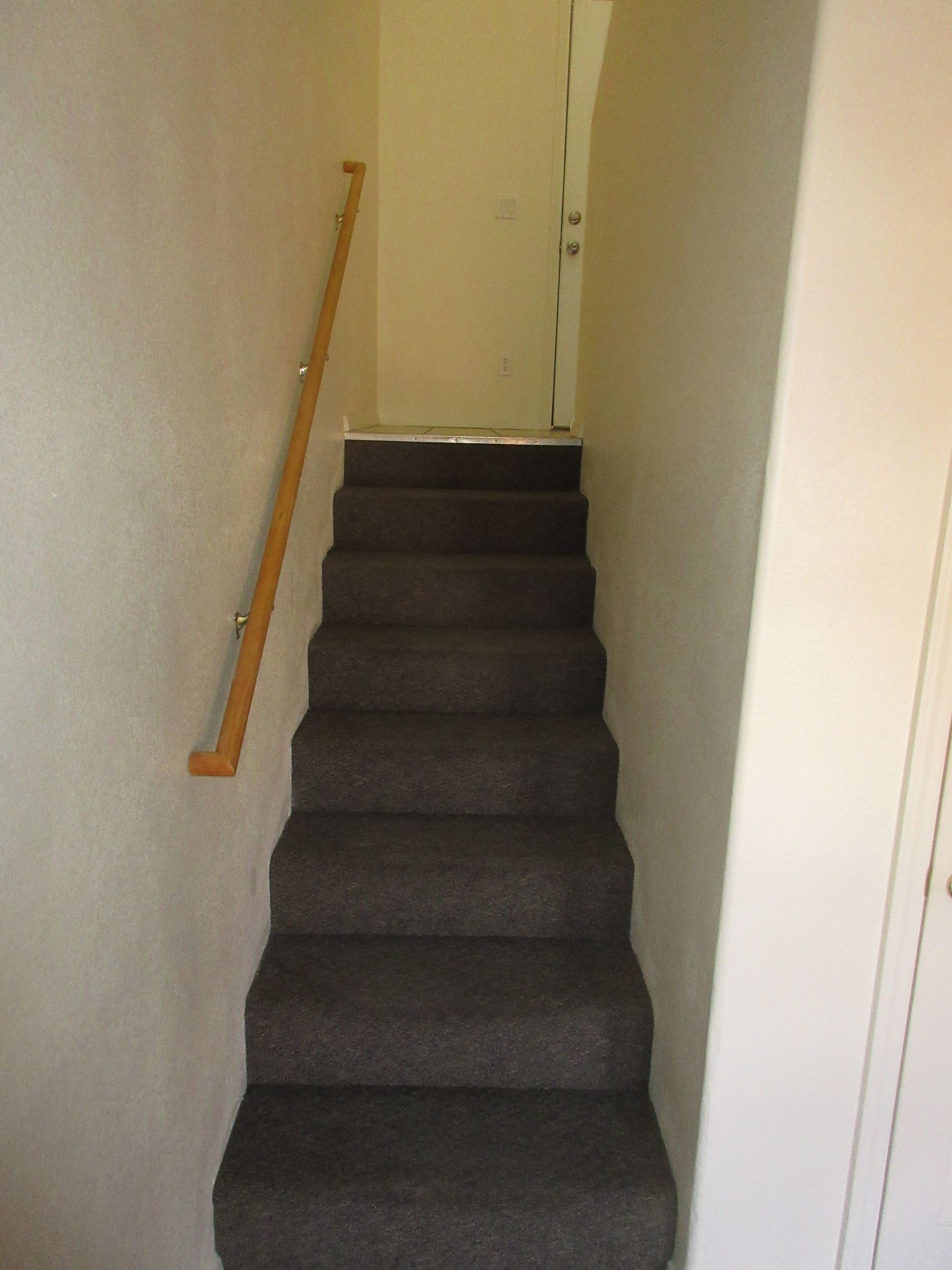 A set of stairs leading up to a door with a wooden railing