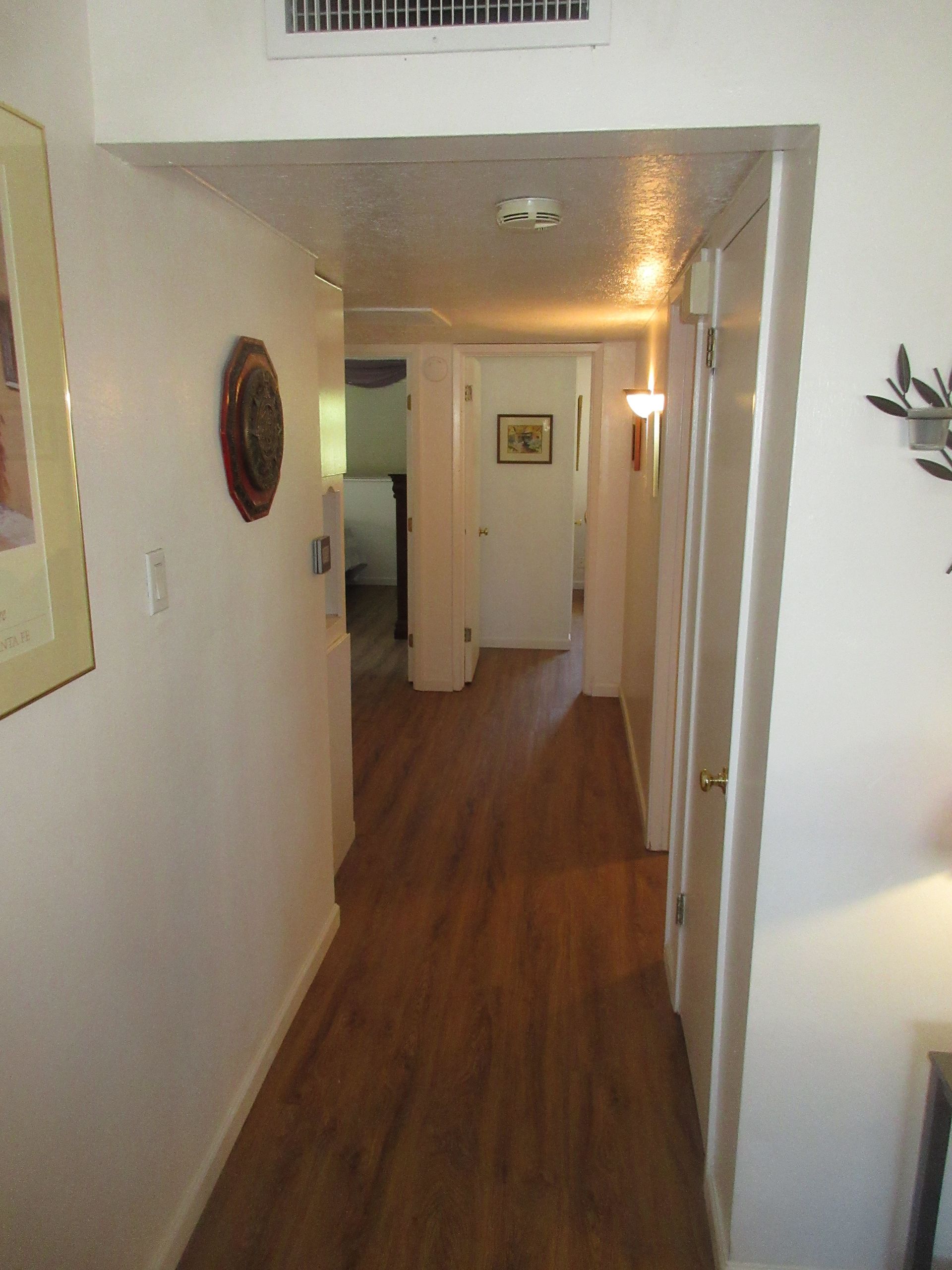 A hallway with wooden floors and white walls