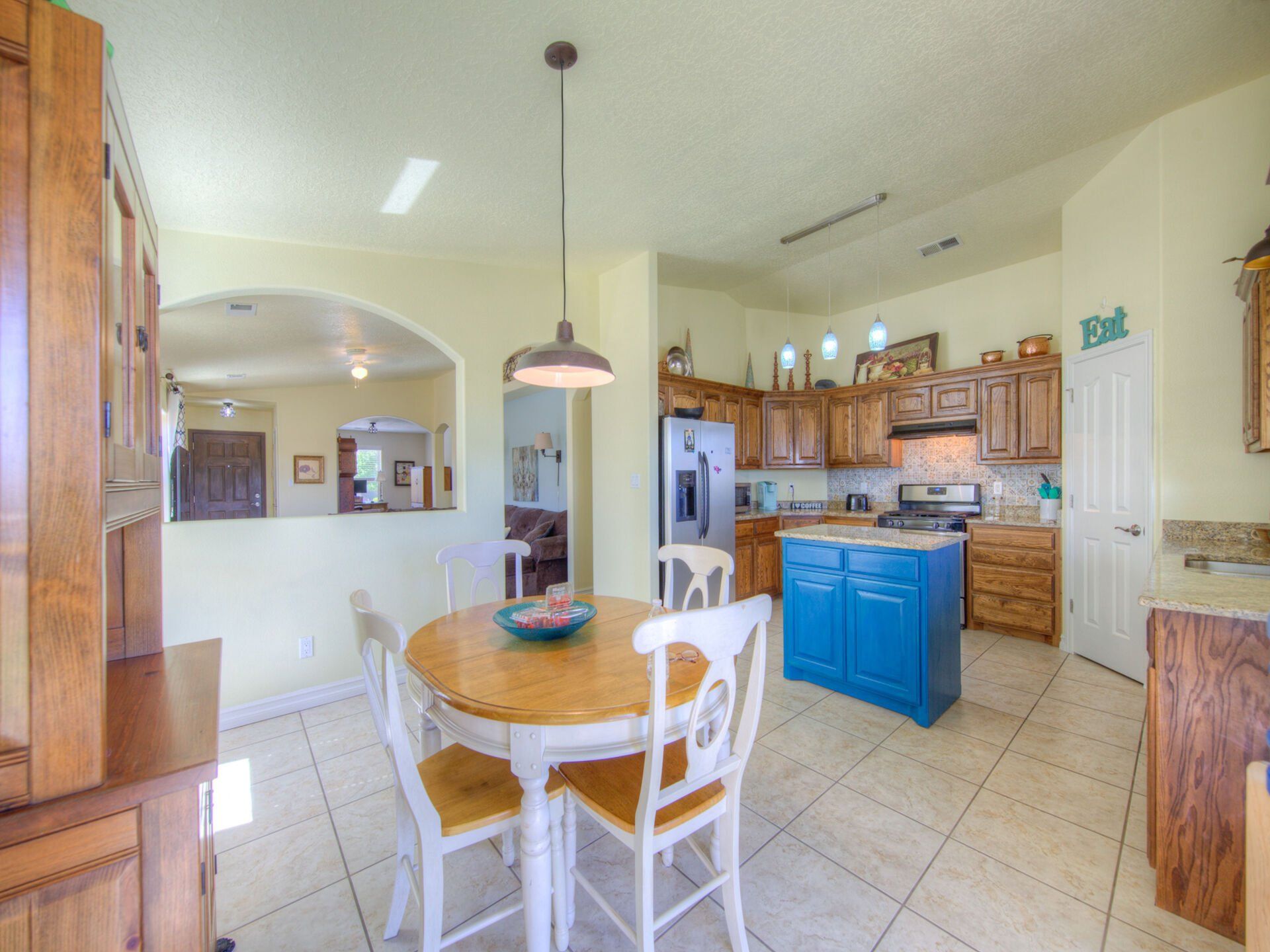 A kitchen with a table and chairs and a blue island