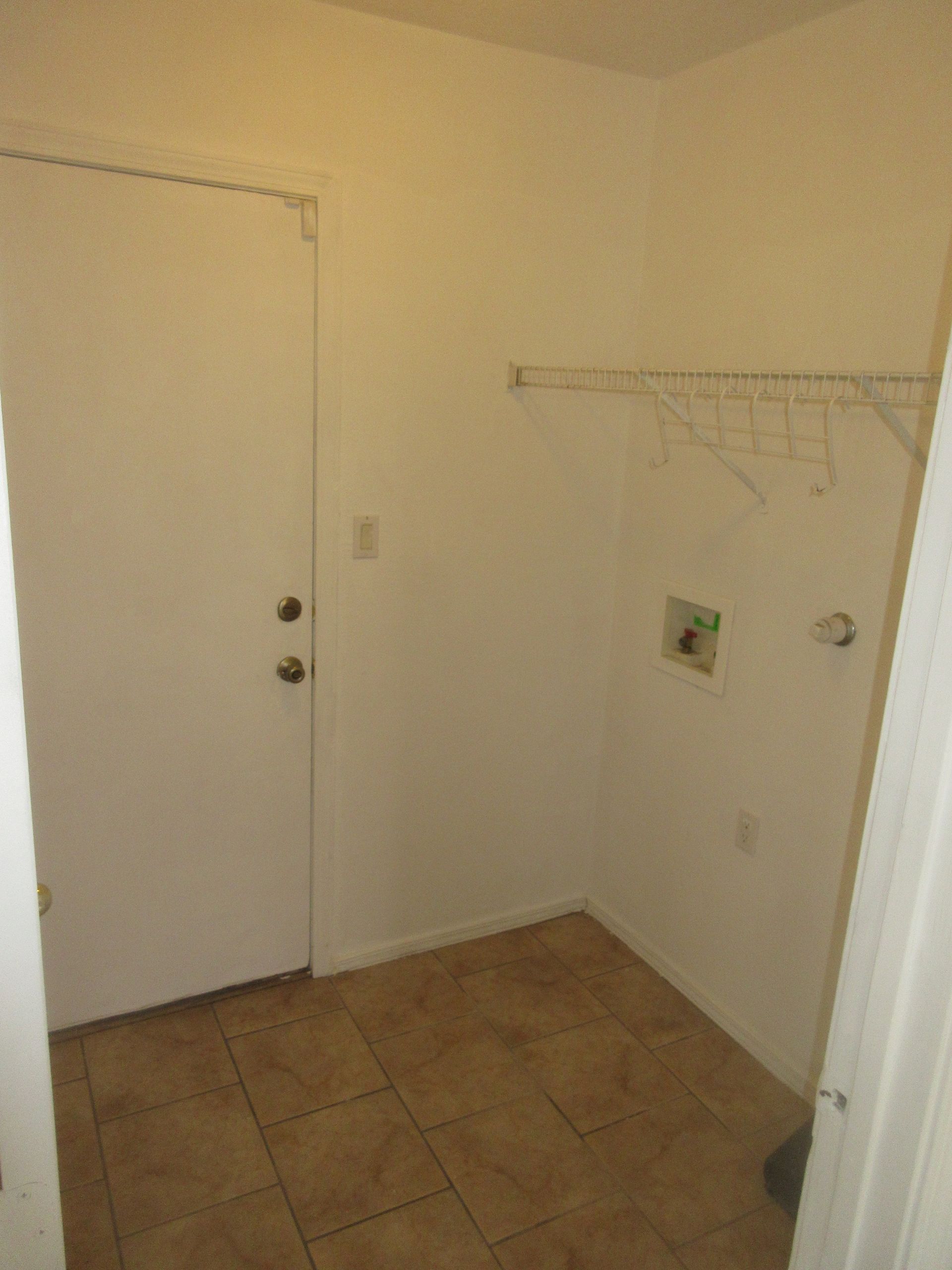 A laundry room with tile floors and a white door