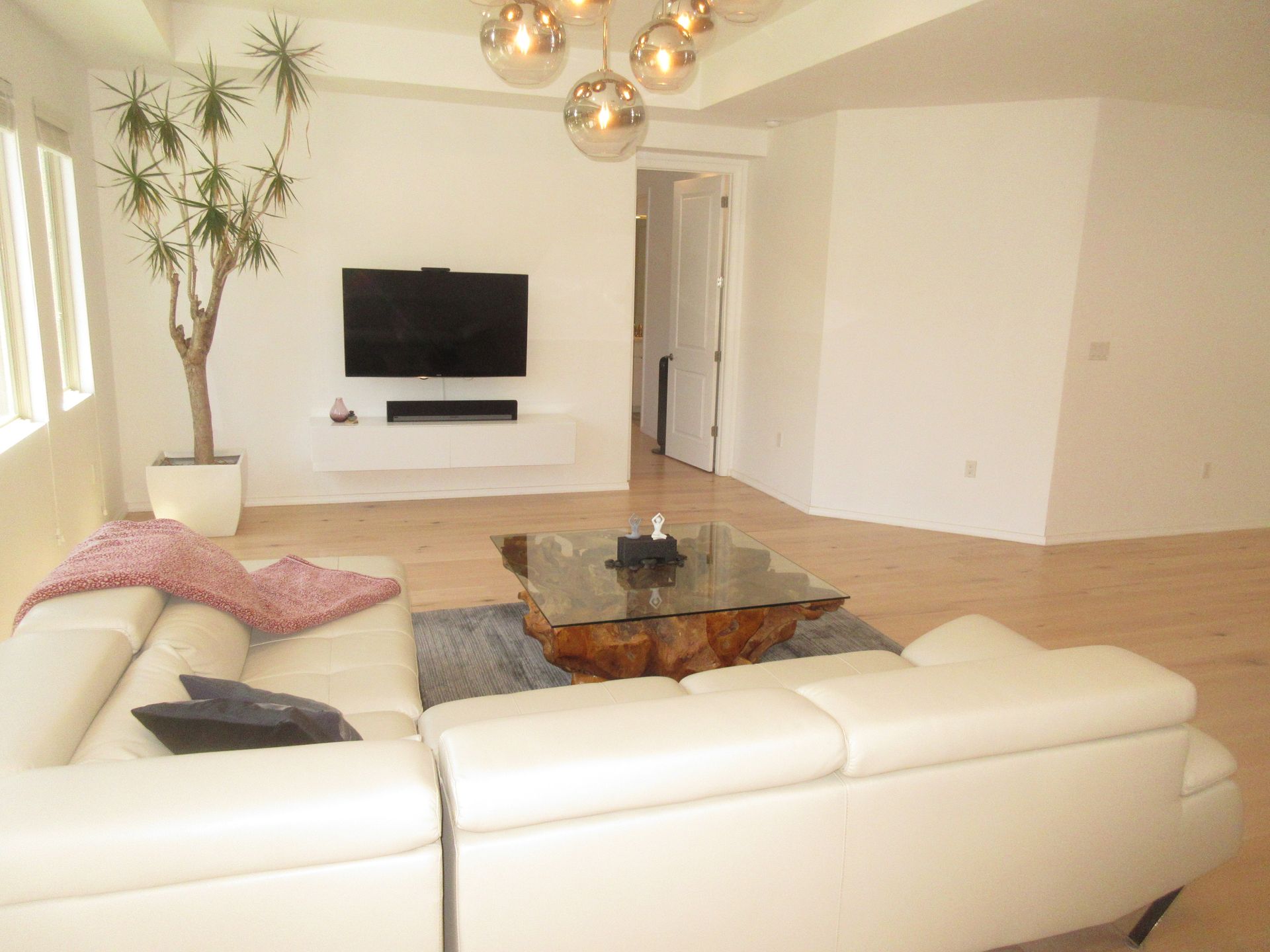 A living room with white furniture and a flat screen tv