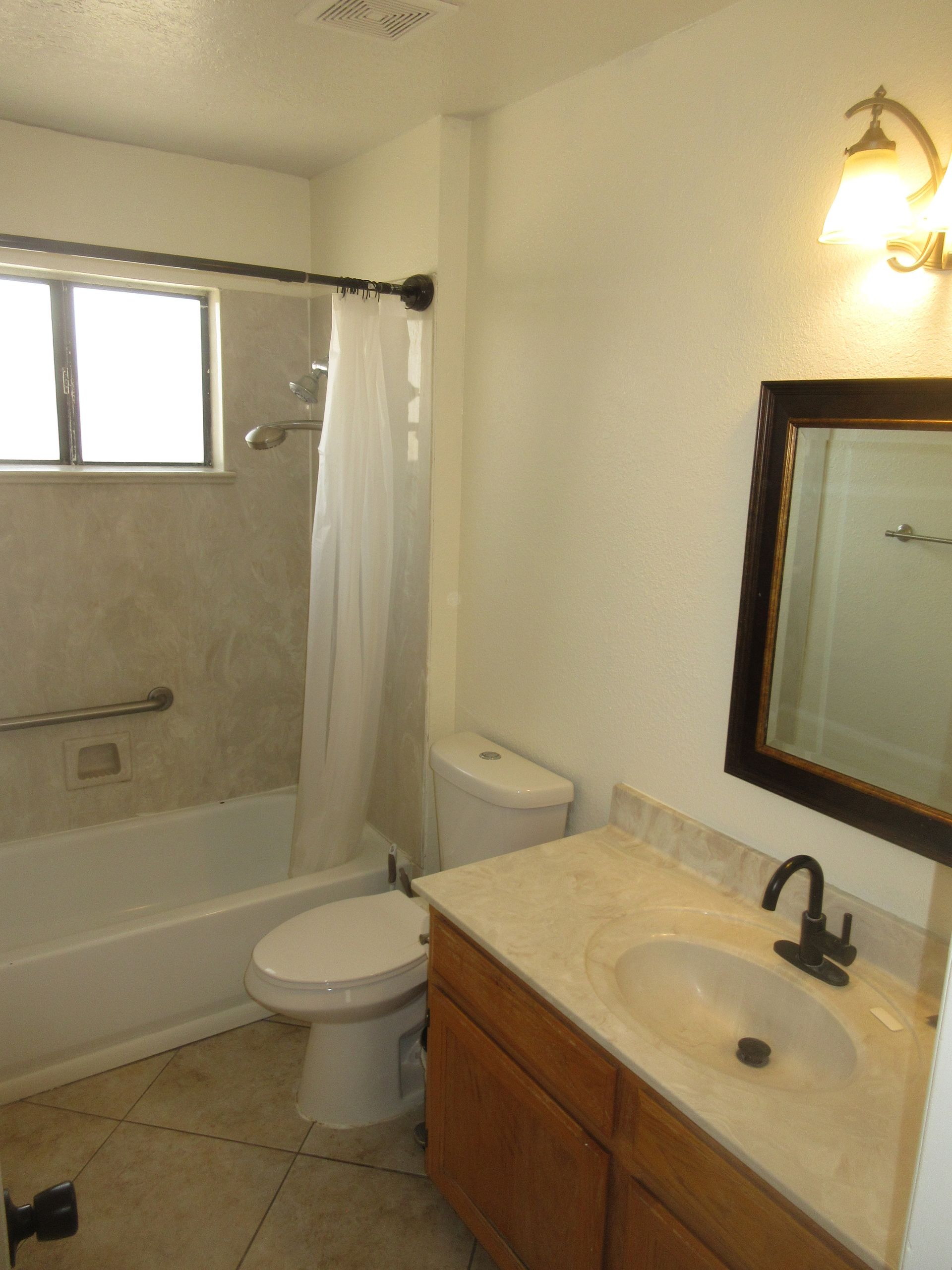 A bathroom with a toilet a sink and a mirror