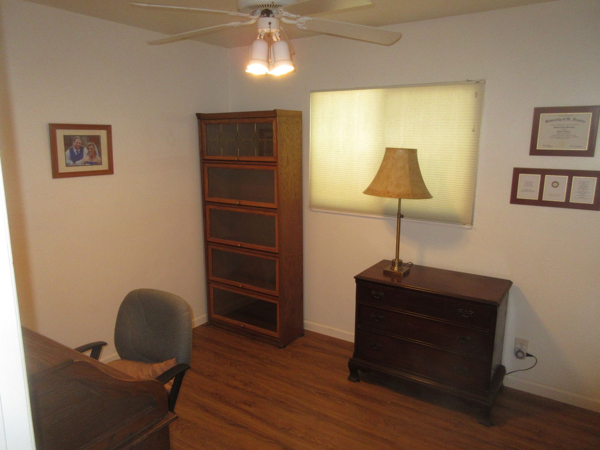 A living room with a ceiling fan and a lamp