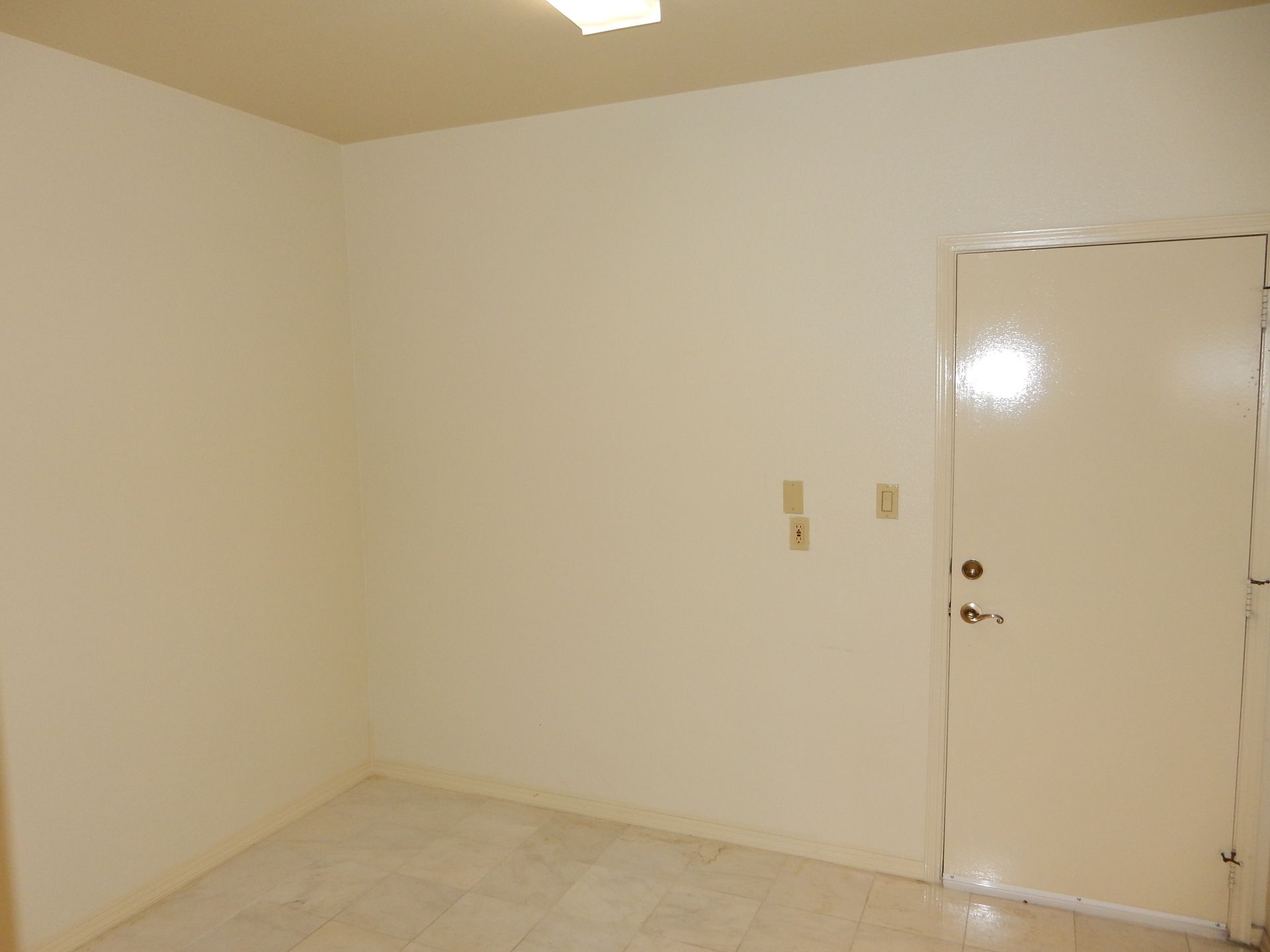 An empty room with white walls and a white door