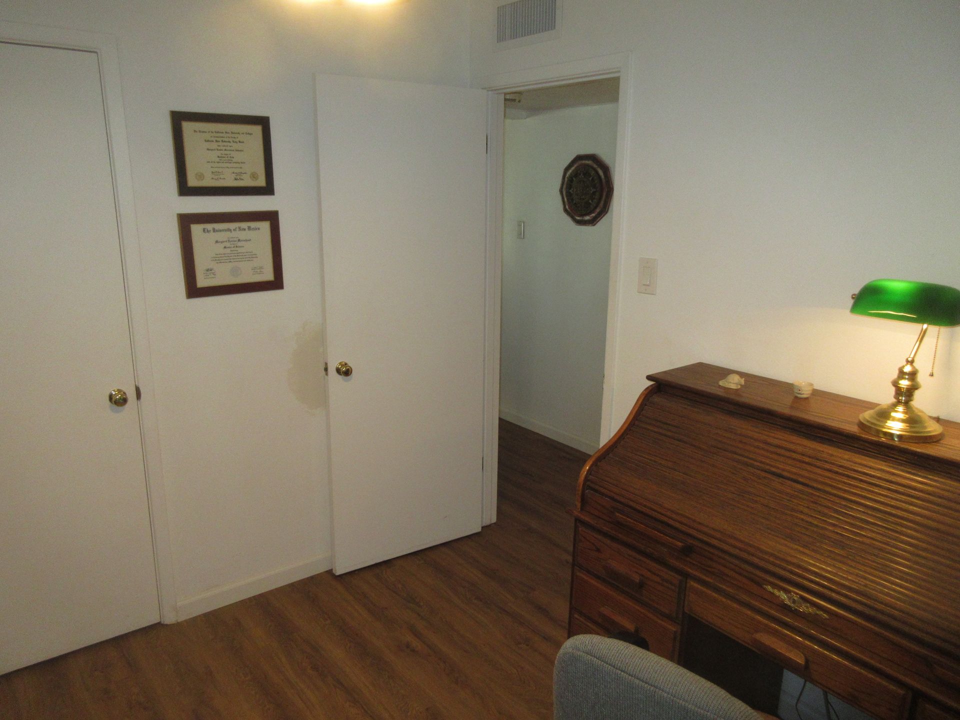 A room with a desk and a green lamp