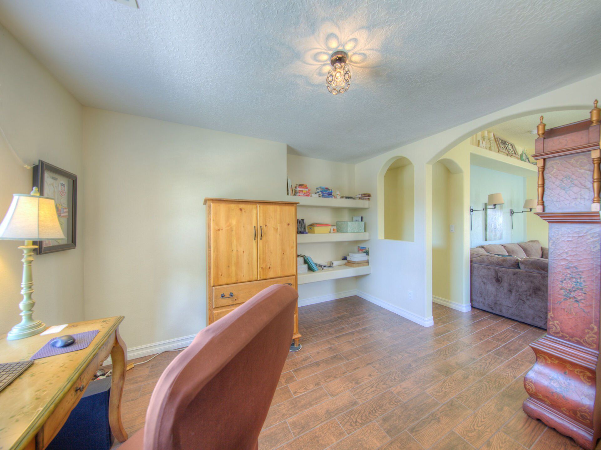 A room with a desk a chair and a clock