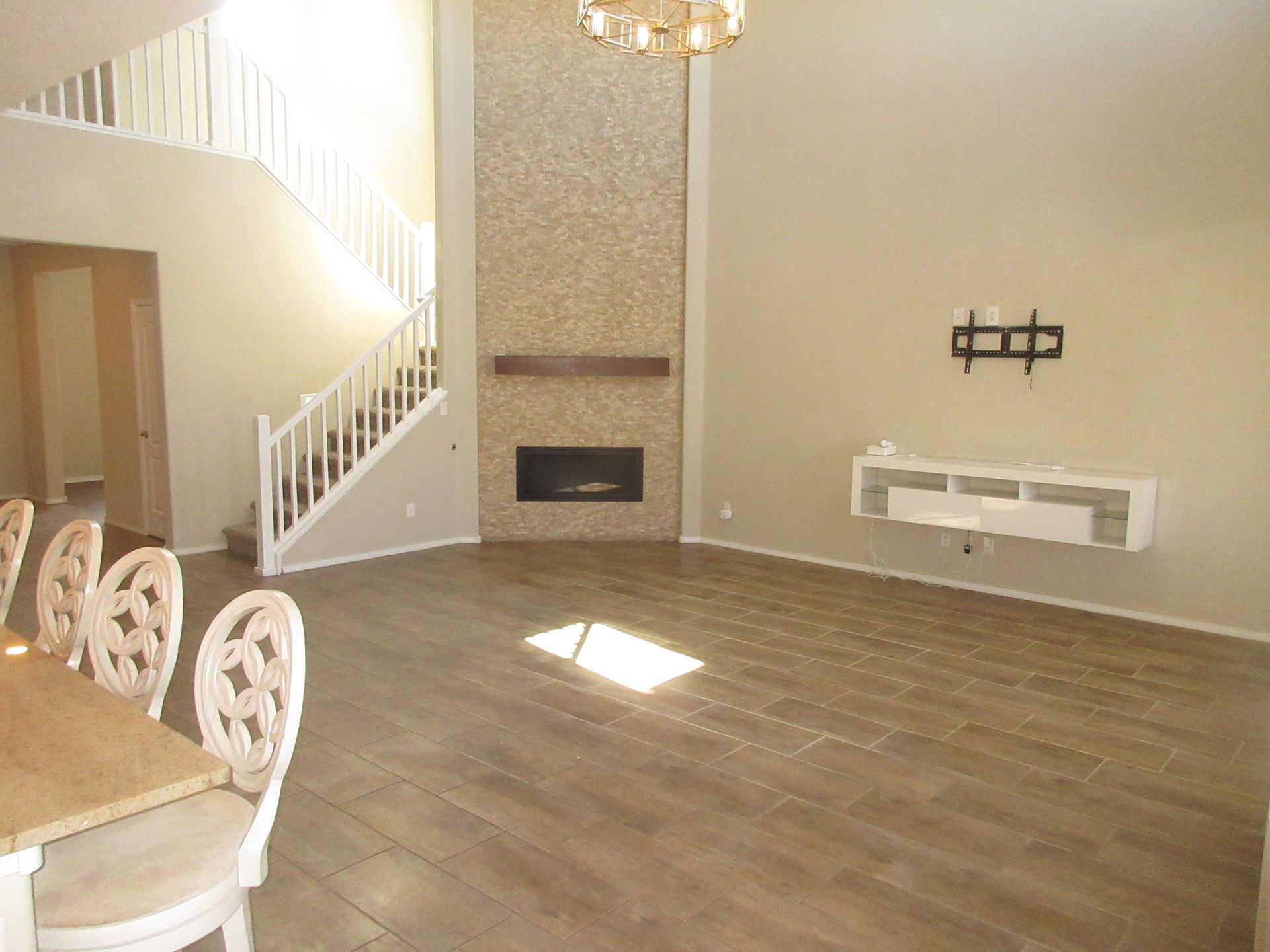 An empty living room with a fireplace and stairs