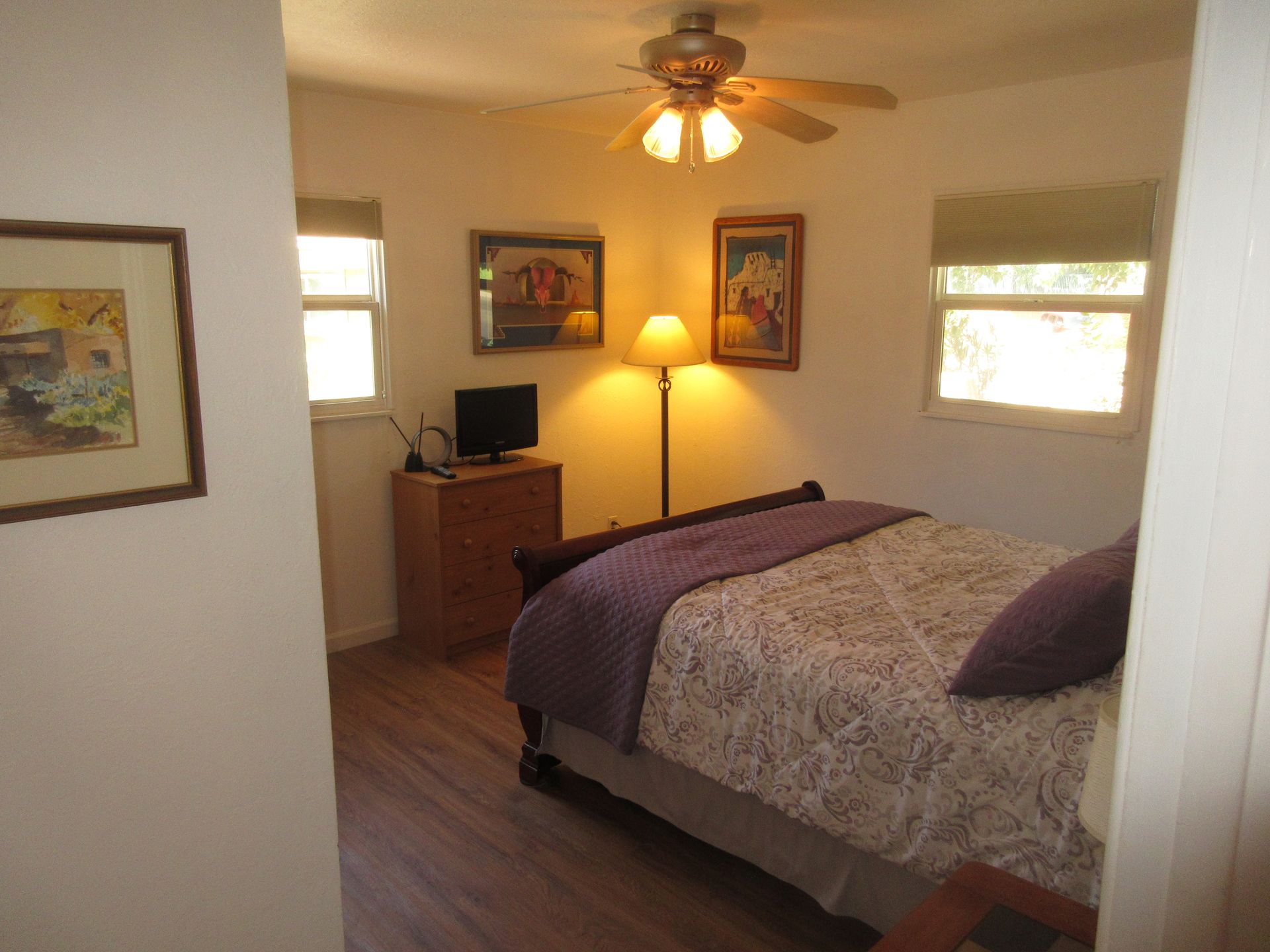 A bedroom with a bed and a ceiling fan