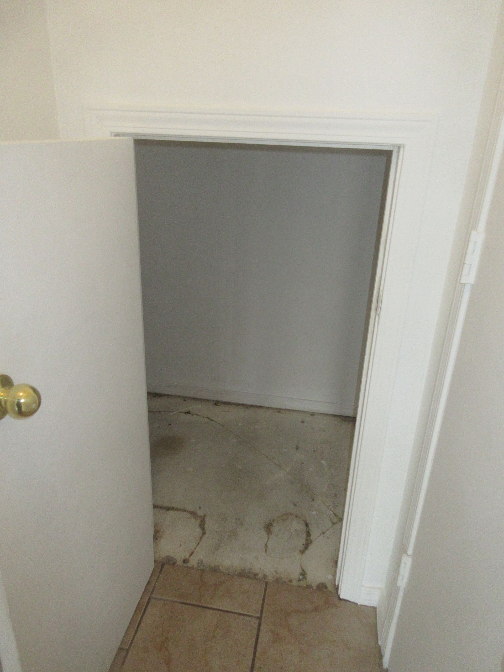 An empty room with a door open and a tiled floor