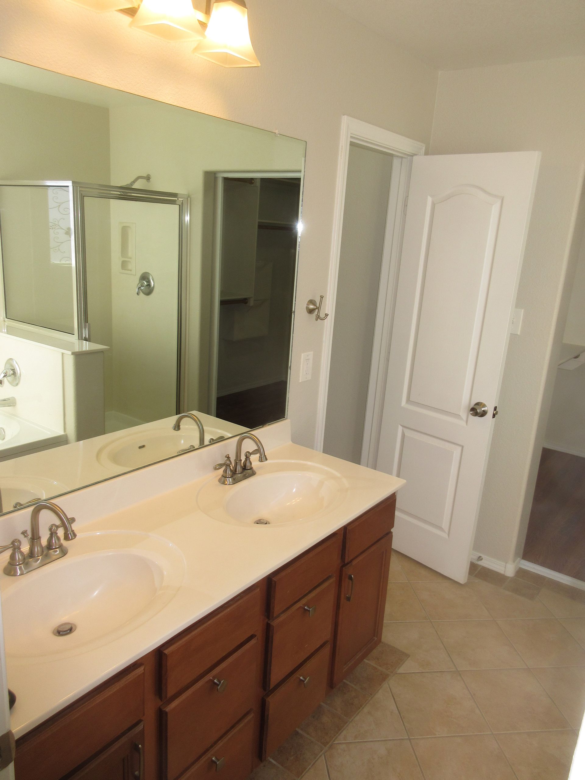 A bathroom with two sinks and a large mirror