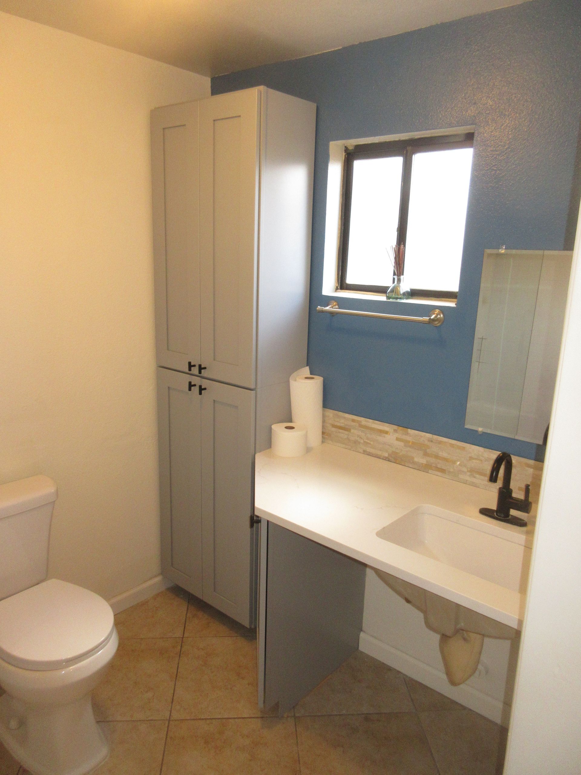 A bathroom with a toilet a sink and a window