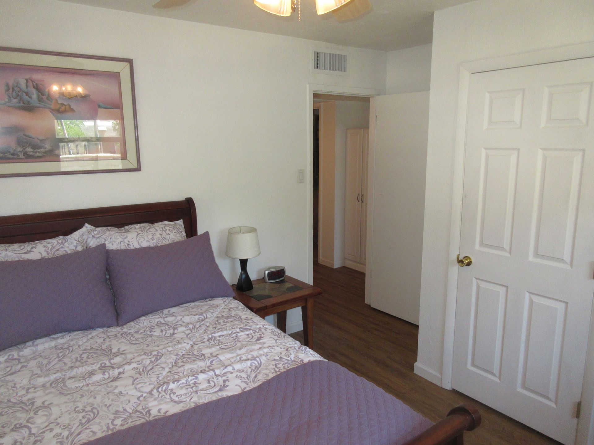 A bedroom with a bed and a picture on the wall