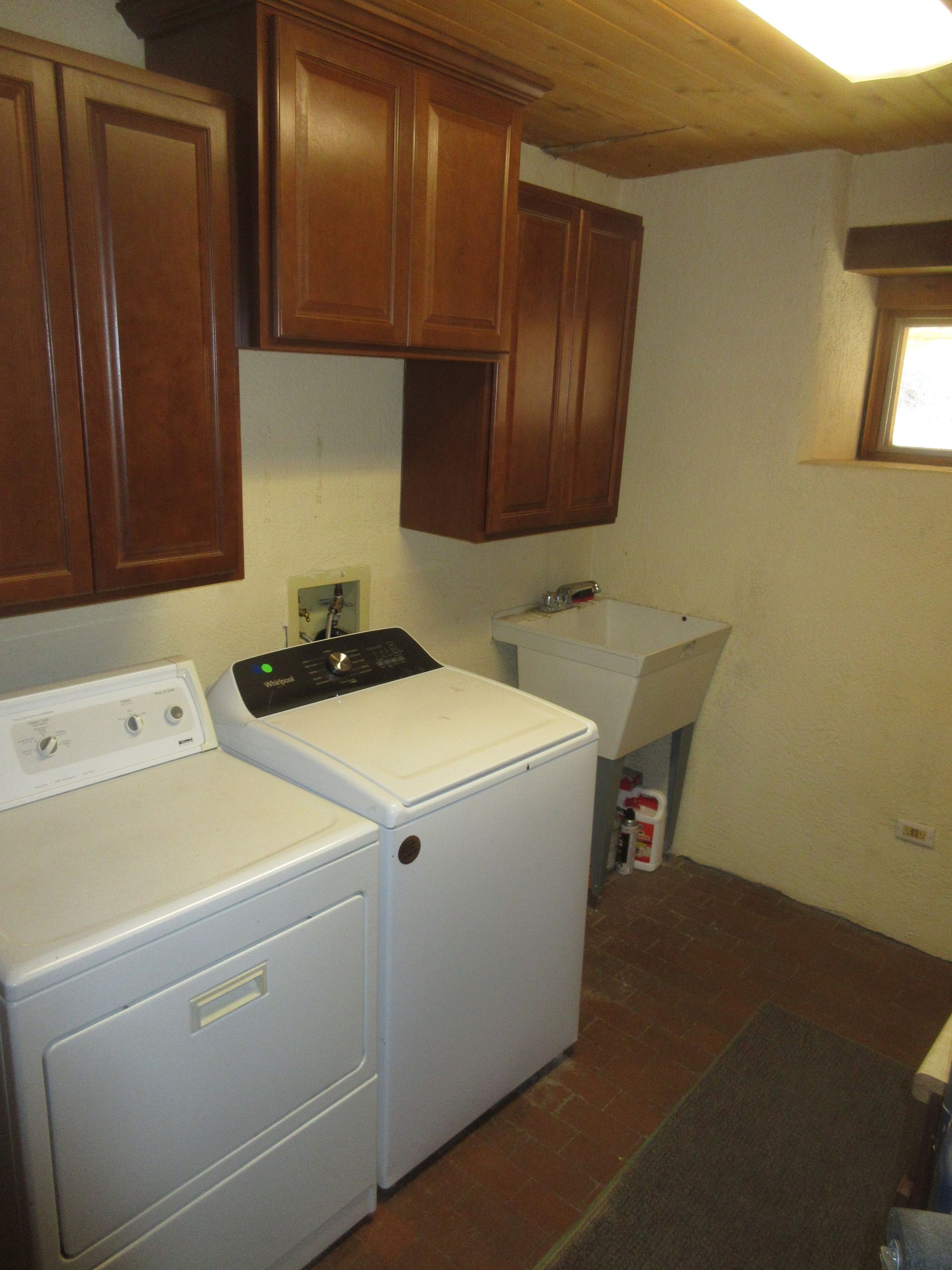 A laundry room with a washer and dryer and a sink