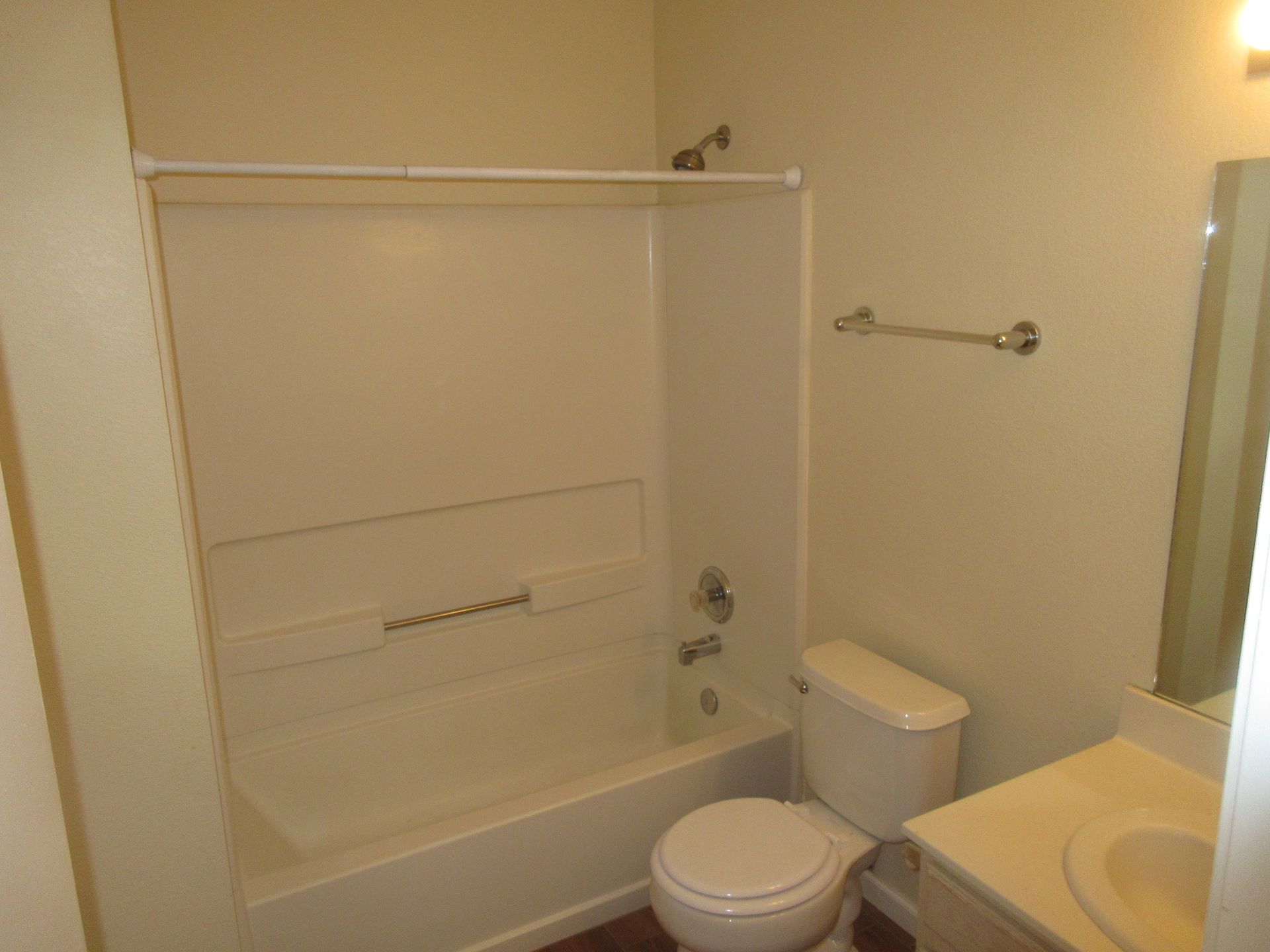 A bathroom with a toilet , bathtub and sink.