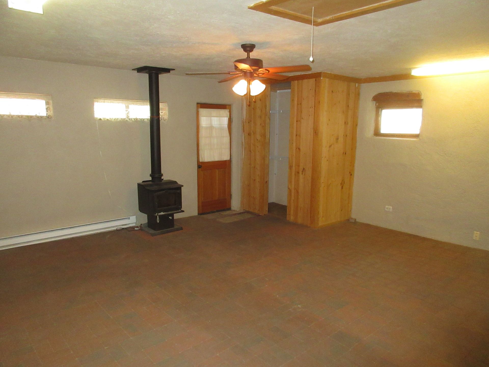 A living room with a wood stove and a ceiling fan