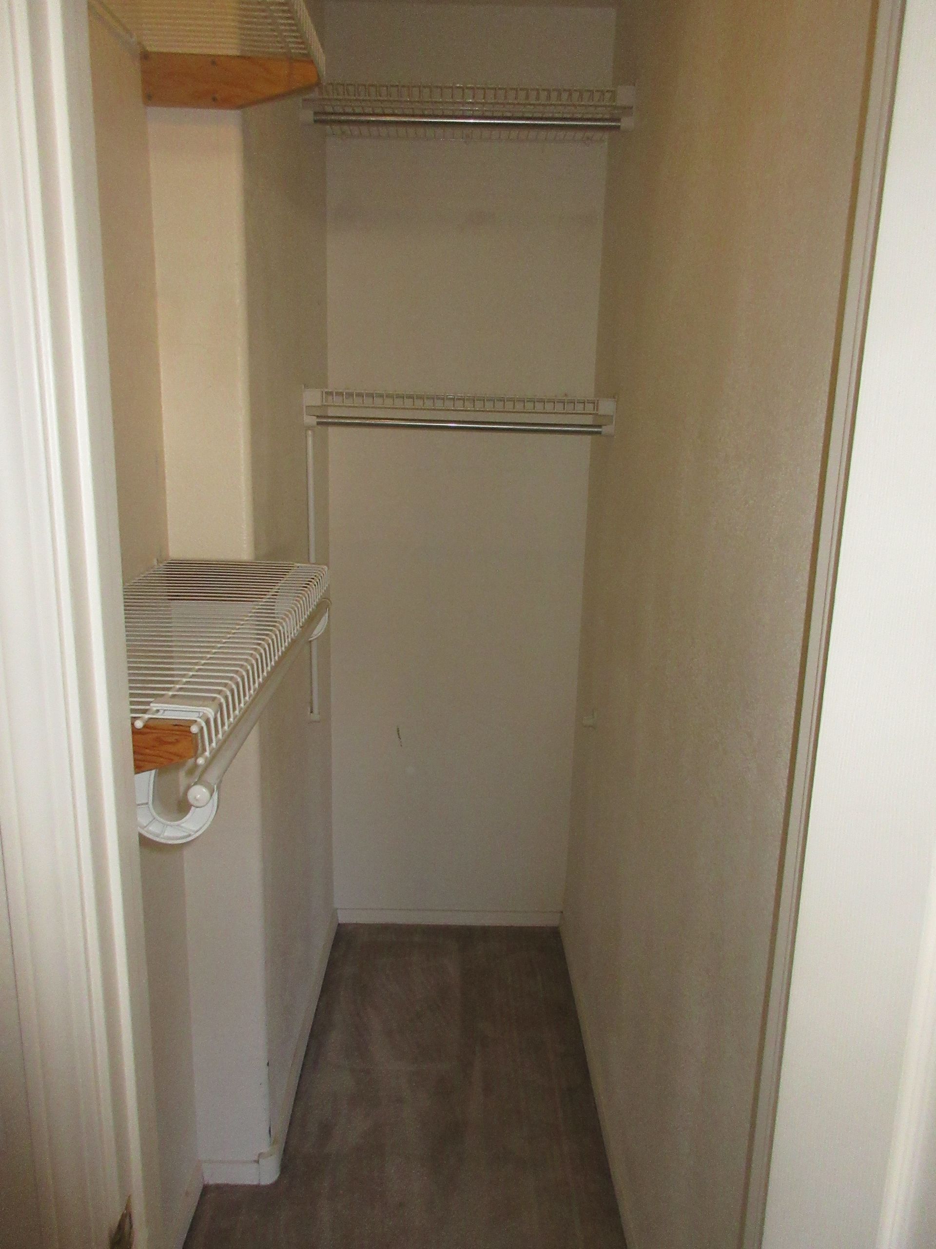 A closet with a sink and a shelf in it.