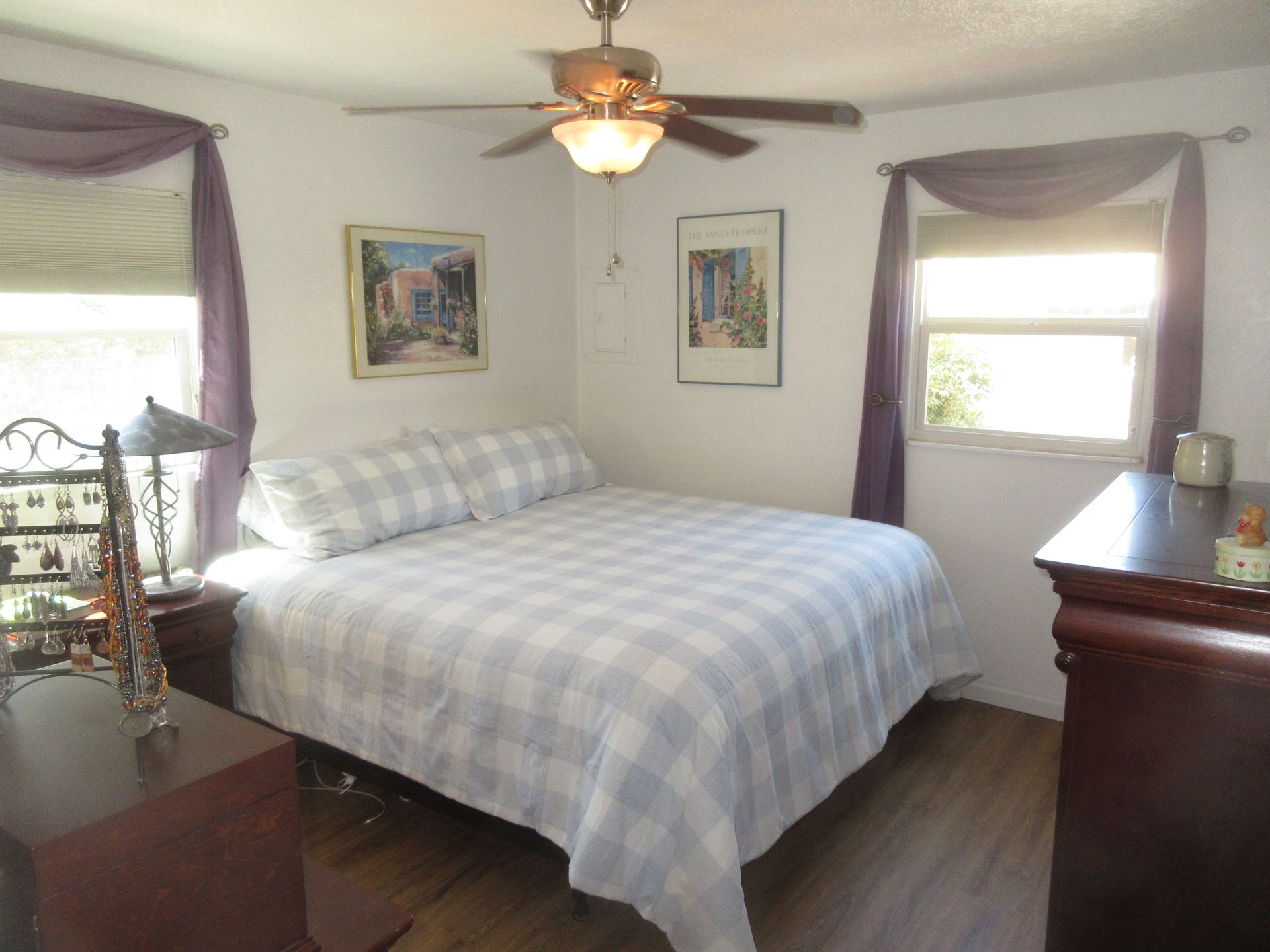 A bedroom with a bed and a ceiling fan